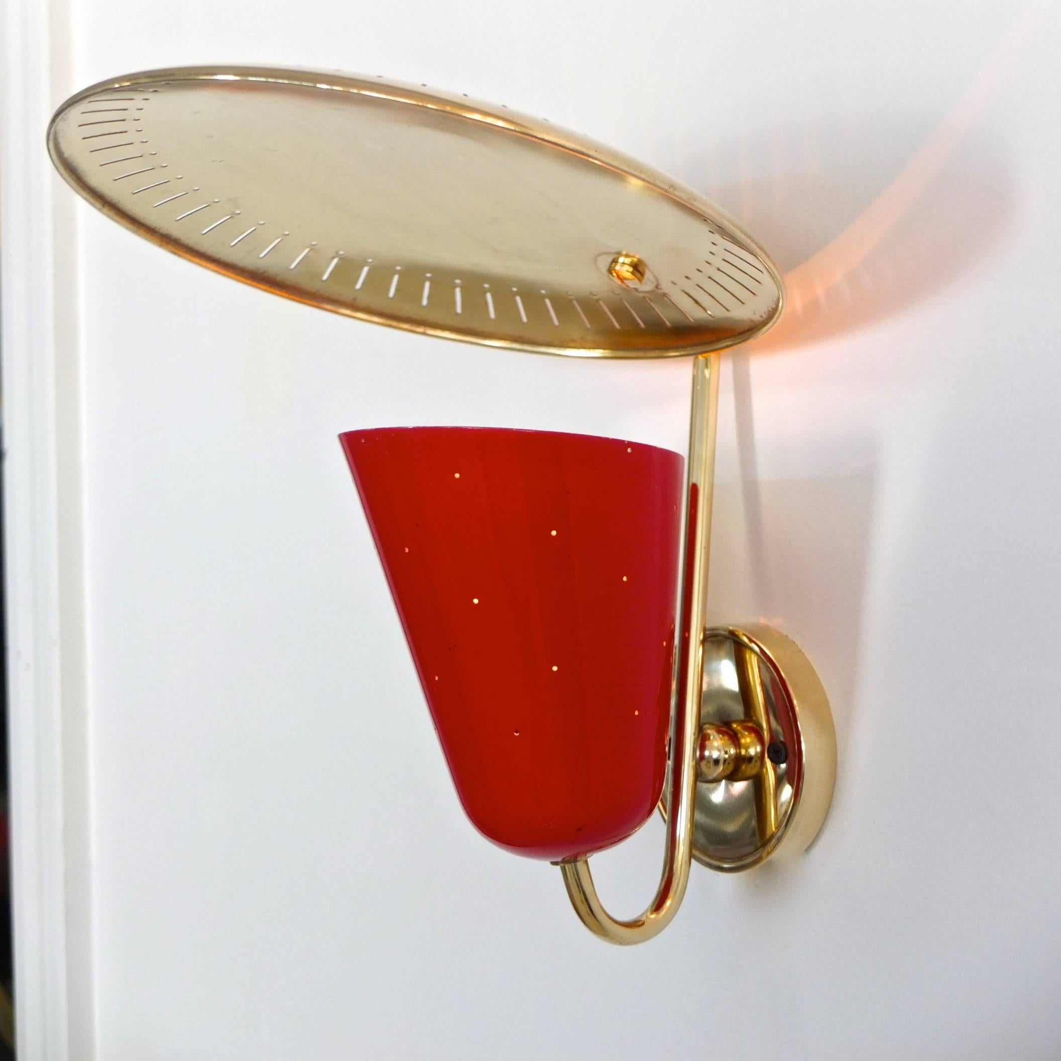 Joyful Mid-Century German wall-mounted lamp by BAG Turgi clearly influenced by Gino Sarfatti with perforated brass dish reflector above a red enameled aluminium cone with pinhole perforations which create a delightful starlight glow.
All original.