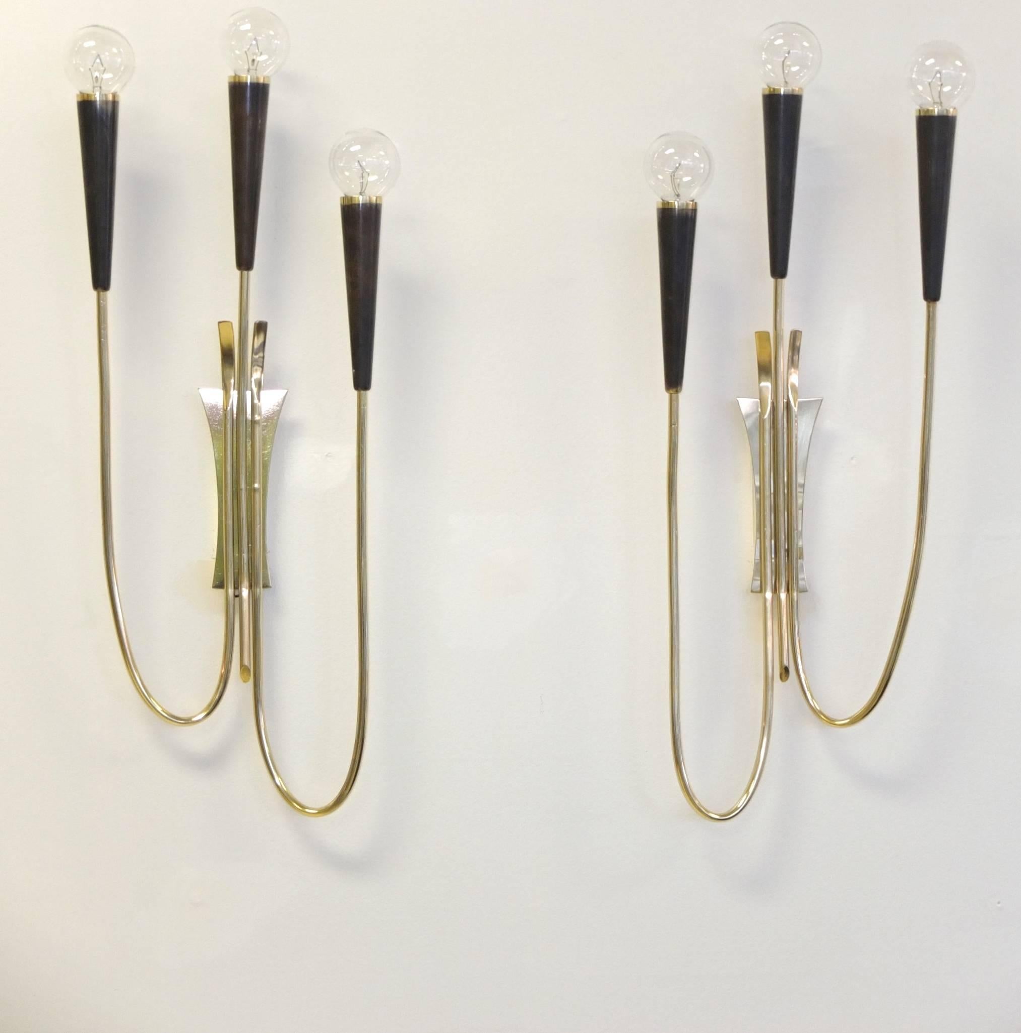 Pair of long and lanky French sconces each with two curled arms and one straight up, each arm terminating in a long brass cone in gunmetal finish with brass rim.