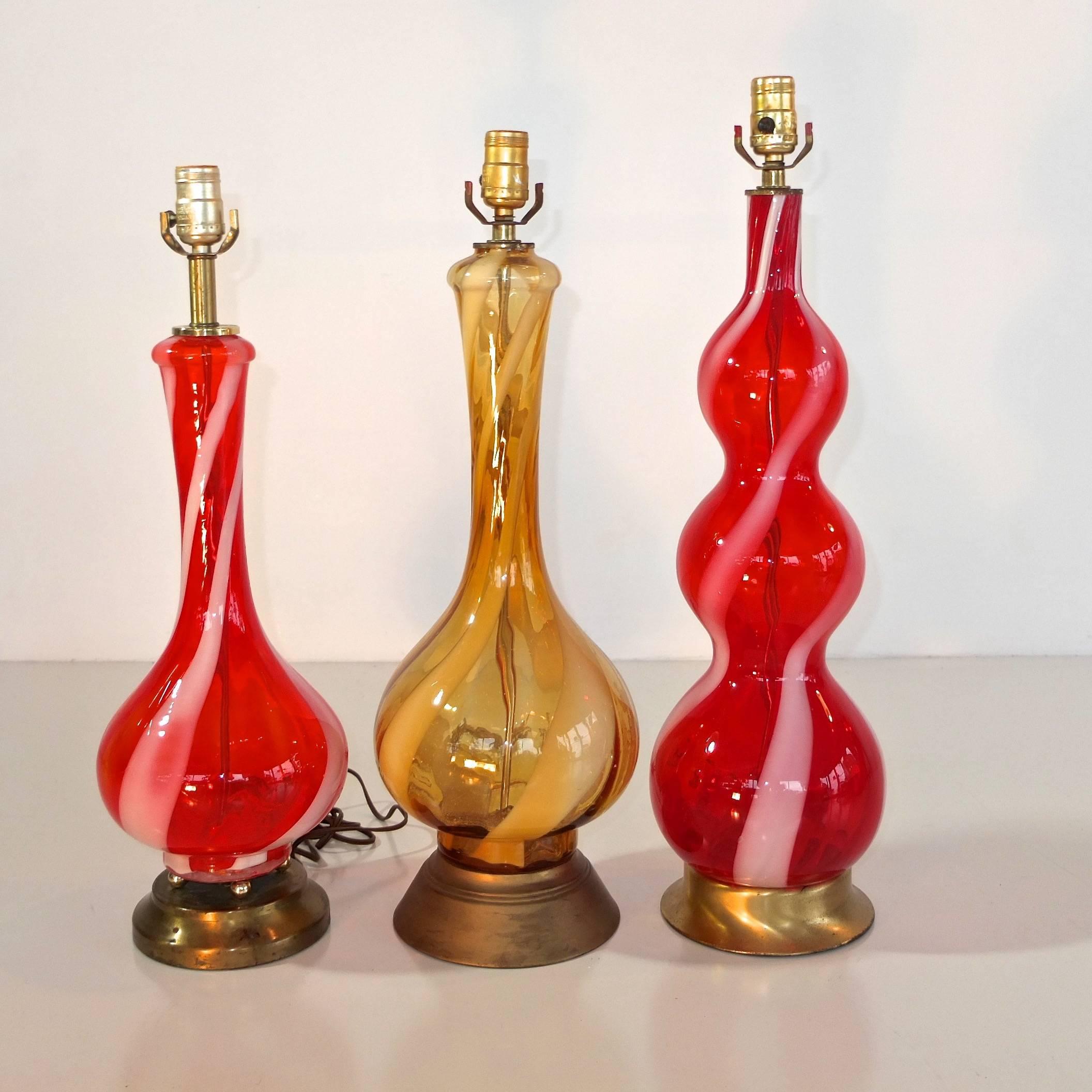 Group of three table lamps, 1960s Murano glass, attributed to Salviati. Two are red glass with white candy swirl. One is yellow-amber with white candy swirl.

Price shown is for the three lamps as shown. 

By request we can re-build these gorgeous