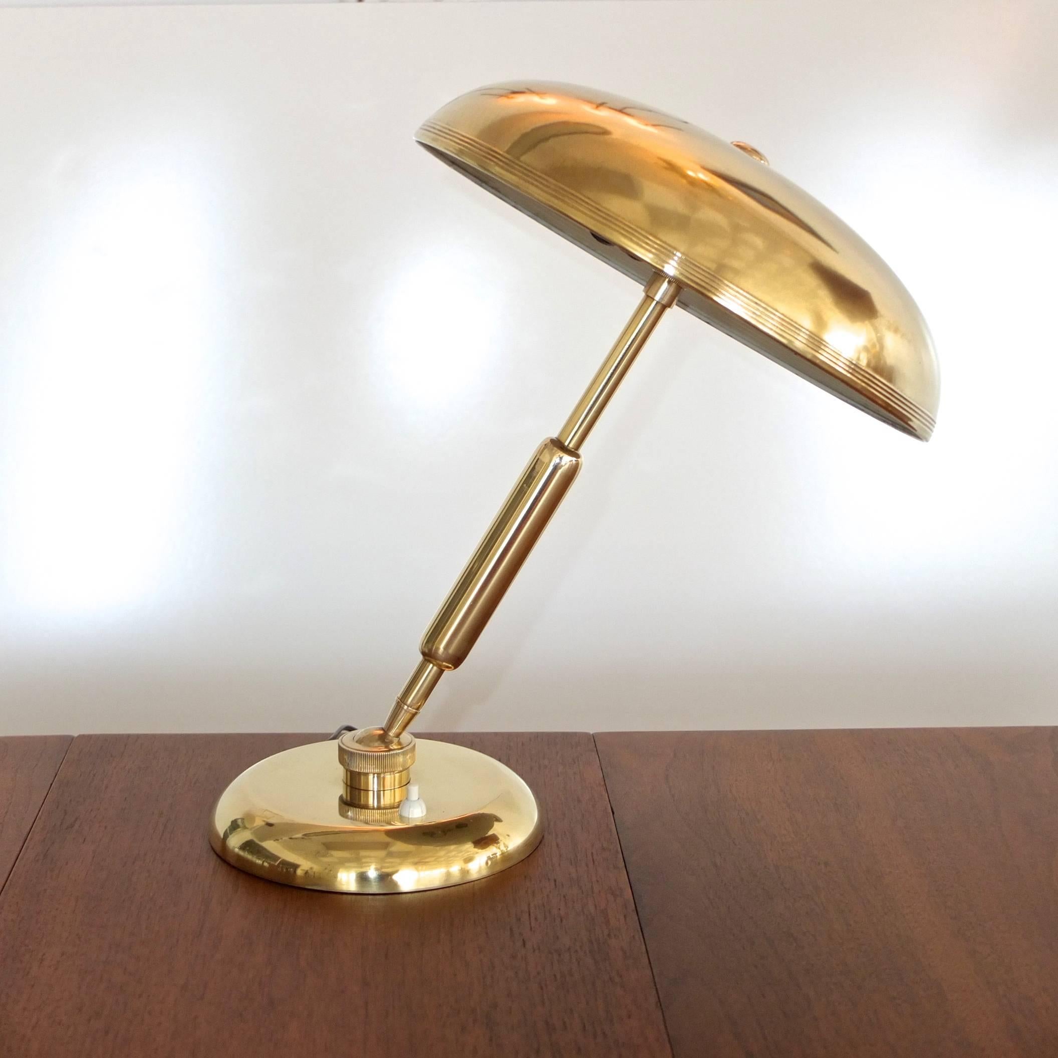 Gorgeous high quality table or desk lamp in solid brass from Italy, 1940s-1950s with a weighted round brass base and an enormous ball joint from which the sturdy stem can pivot ~140 x 360 degrees. The round brass domed mushroom head is also attached