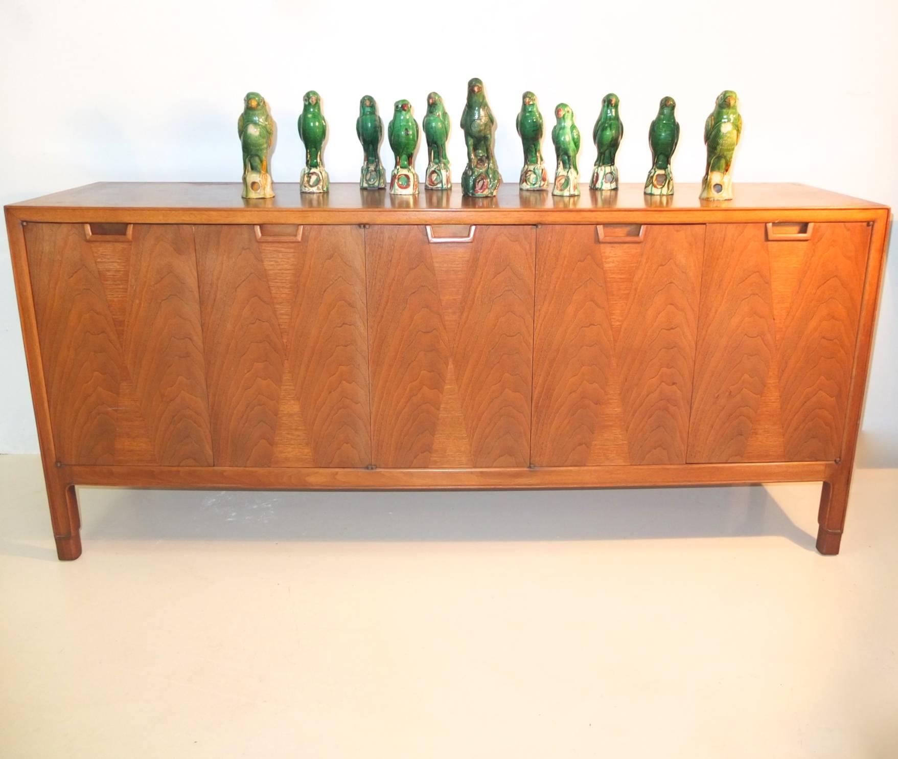 Mid-Century Modern walnut five-door sideboard with vertical bowtie inlay produced by Mt. Airy for John Stuart's Janus Collection. First two doors open to reveal three drawers. Third, fourth and fifth door open to cabinet divided by a single fixed