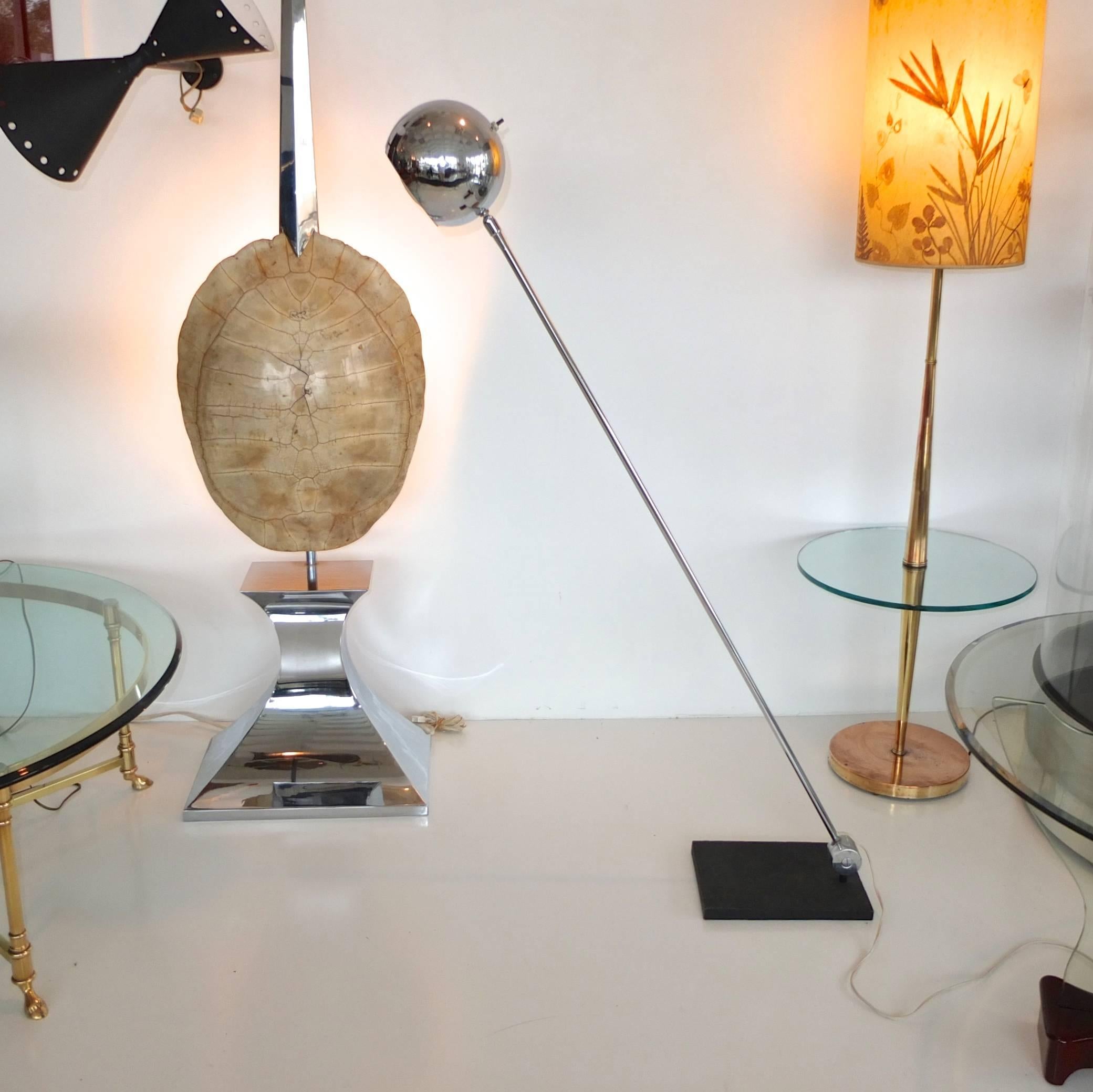 Lampadaire articulé des années 1960 par Robert Sonneman avec abat-jour en forme de globe oculaire chromé attaché par un joint articulé à la longue tige chromée à la base de laquelle se trouve la lourde rotule articulée qui permet à la lampe de