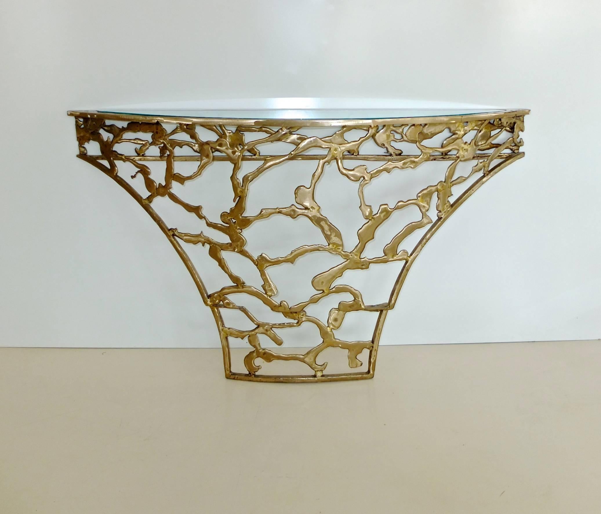 Custom solid bronze console table by Silas Seandal in his style known as B.F. Ribbon....B.F. for bronze filigree with an inset glass top. This is a demilune shaped table that was made to fit snuggly into a curved wall niche with the flat edge facing