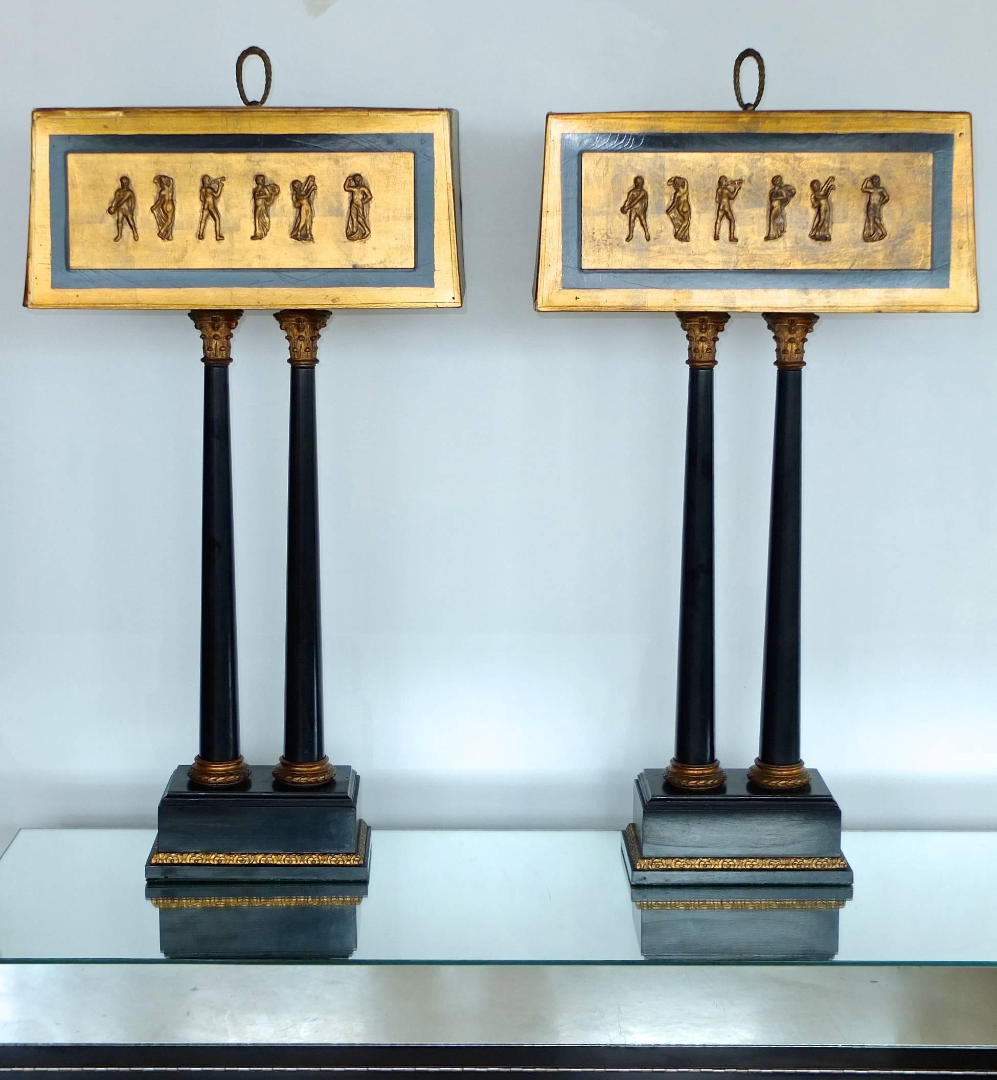 These lamps are very dramatic and quite camp, quasi Versace! 

Pair of vintage 1950s neoclassical style table lamps with ebonized double columns with gilt metal Corinthian capitals and bases mounted on a classical rectangular plinth, embellished