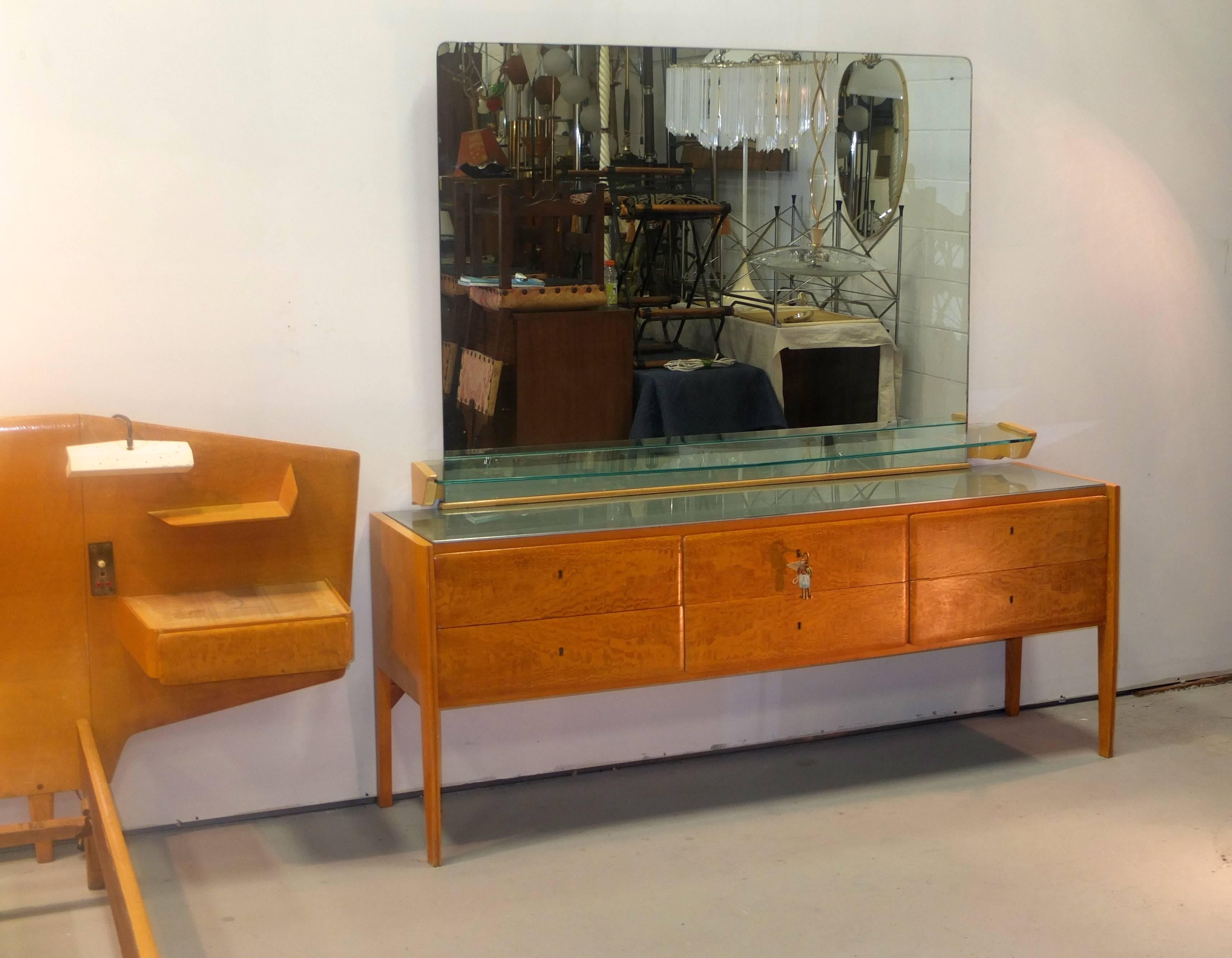 Gio Ponti long cabinet of six drawers standing on four legs which themselves are integral to the case. Dresser has silvered reverse painted glass top and is surmounted with a large rectangular mirror and a floating glass shelf cut in Ponti's