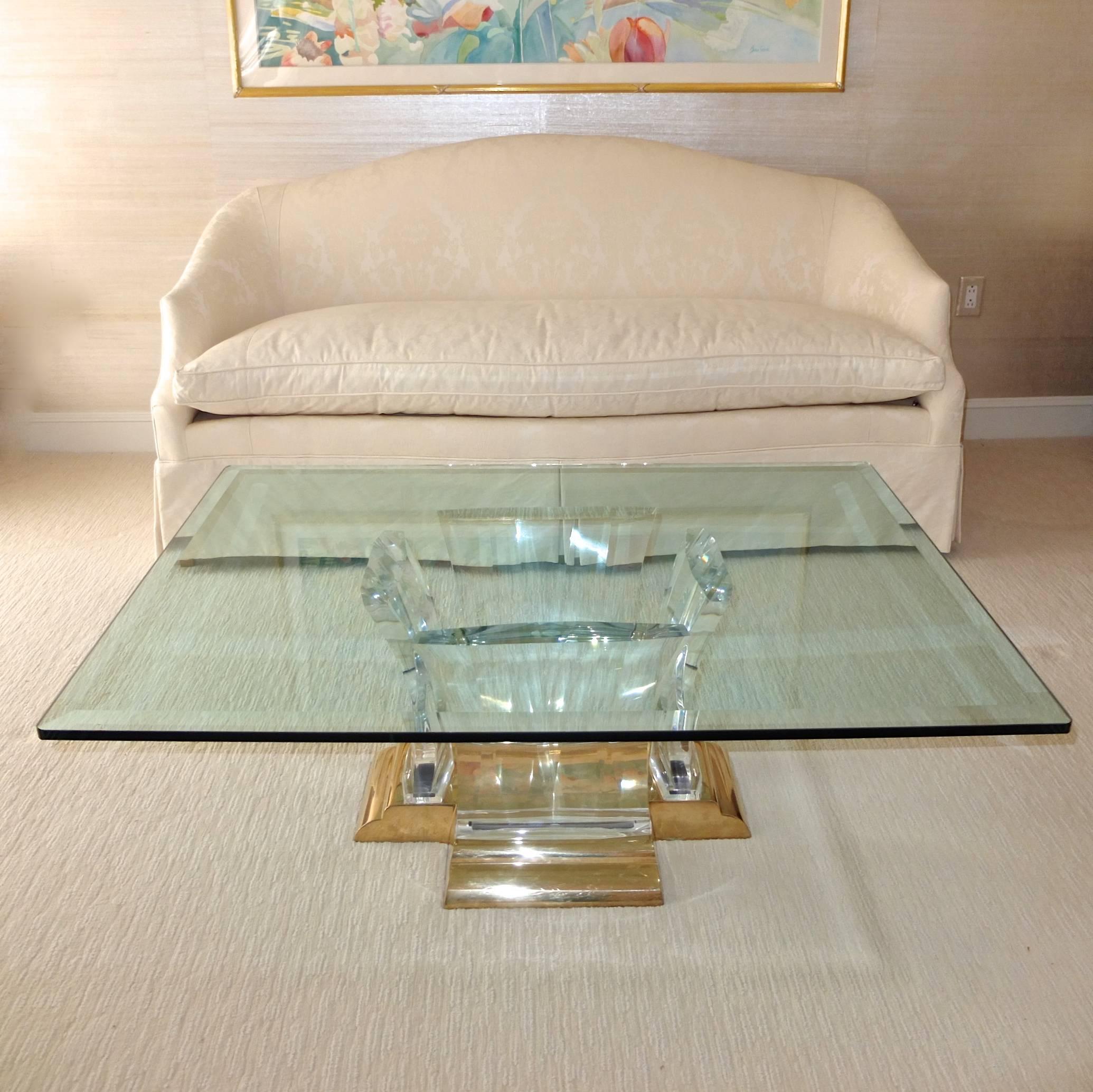 Washington cocktail table by Spectrum Limited. Very thick bevelled glass top 36 inches by 48 inches. Rectangular form polished cast brass base with four curved and prismatic 2 inch thick Lucite supports which support the glass top.
Dimensions of