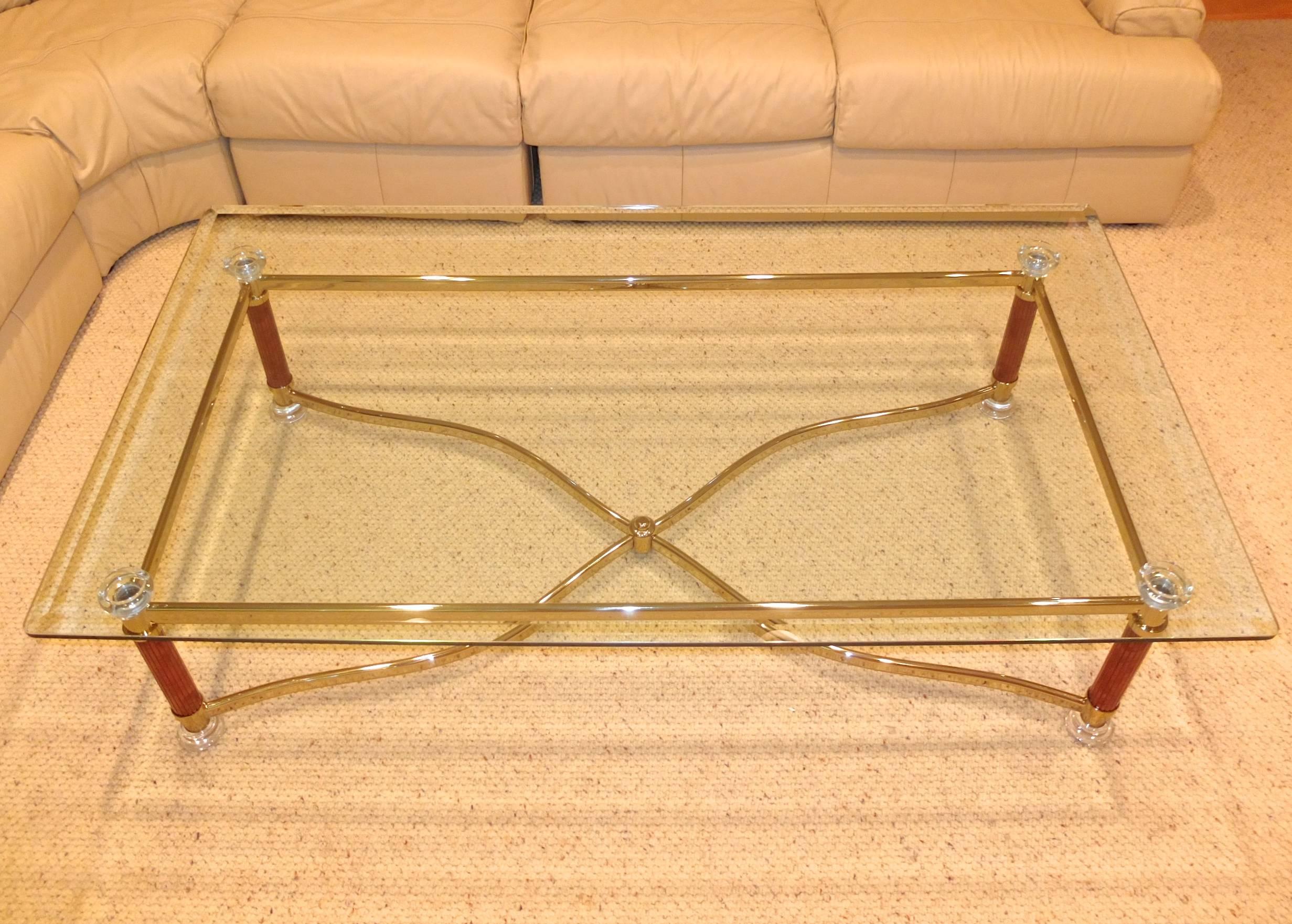 Rectangular beveled glass top cocktail table with four round column legs clad in tamboured faux jasper stone with round Lucite Doric capitols and feet, serpentine brass cruciform stretcher base and straight brass sides. 

Vintage early 1980s.