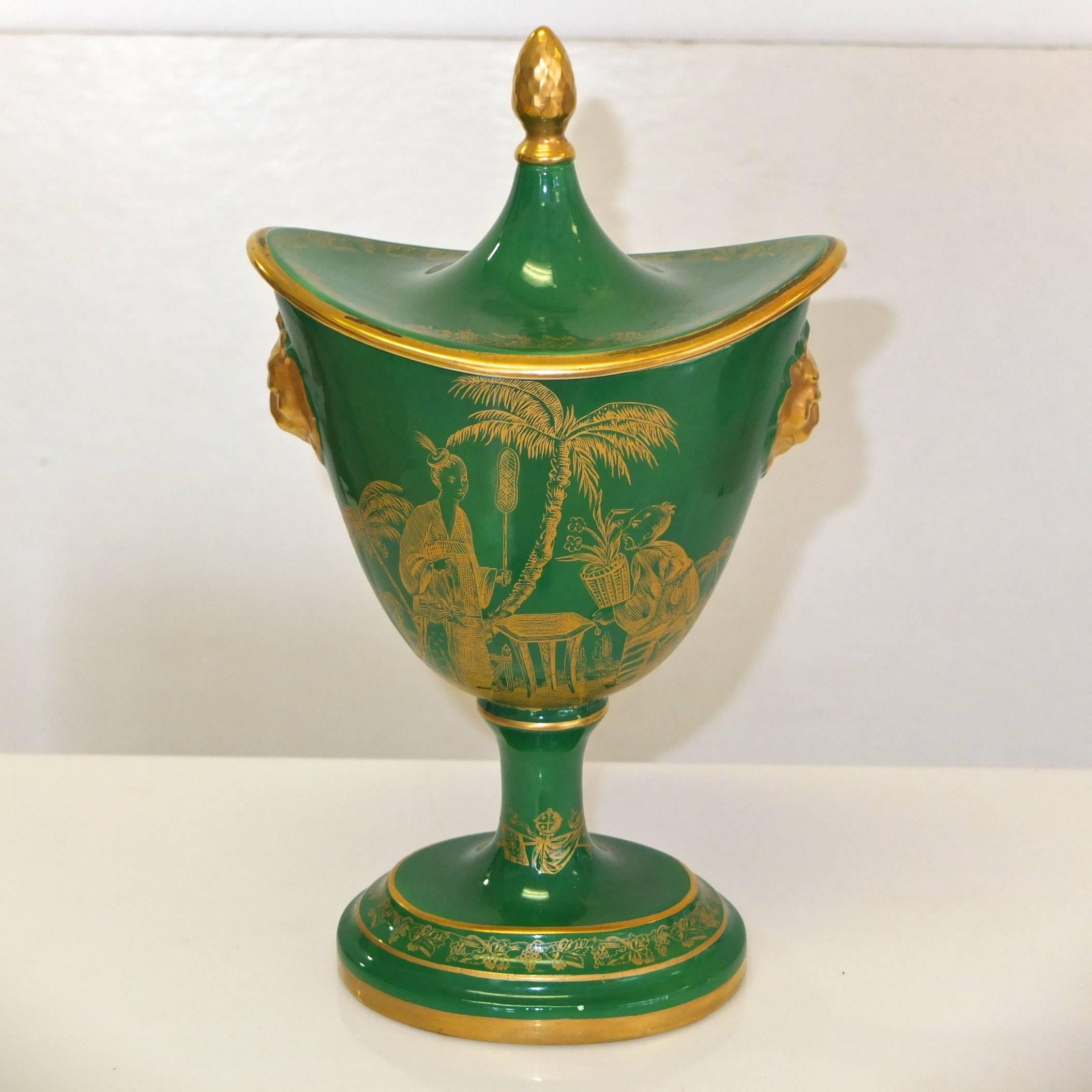Lidded cachepot made in Italy for the Mottahedeh company, known for their luxury ceramic antique reproductions and historic designs. Gold transfer ware on green ground. Orientalist scene with figures. Lid with gold finial and rim. Gold lions on left