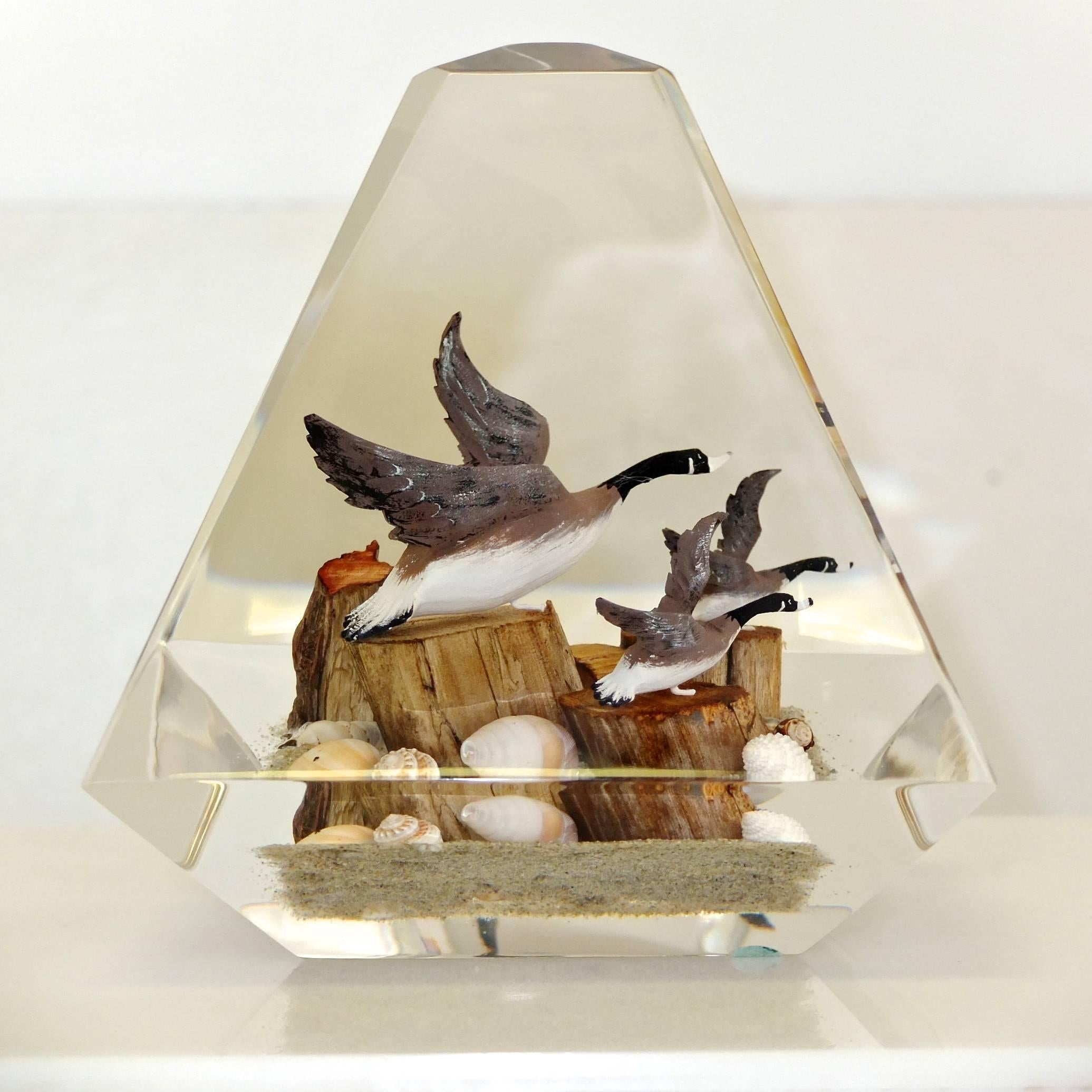 Immaculate and intensely clear obelisk-form sculpture of a wildlife scene with geese, ducks, driftwood, sea shells and pebbles encased in polished perspex.