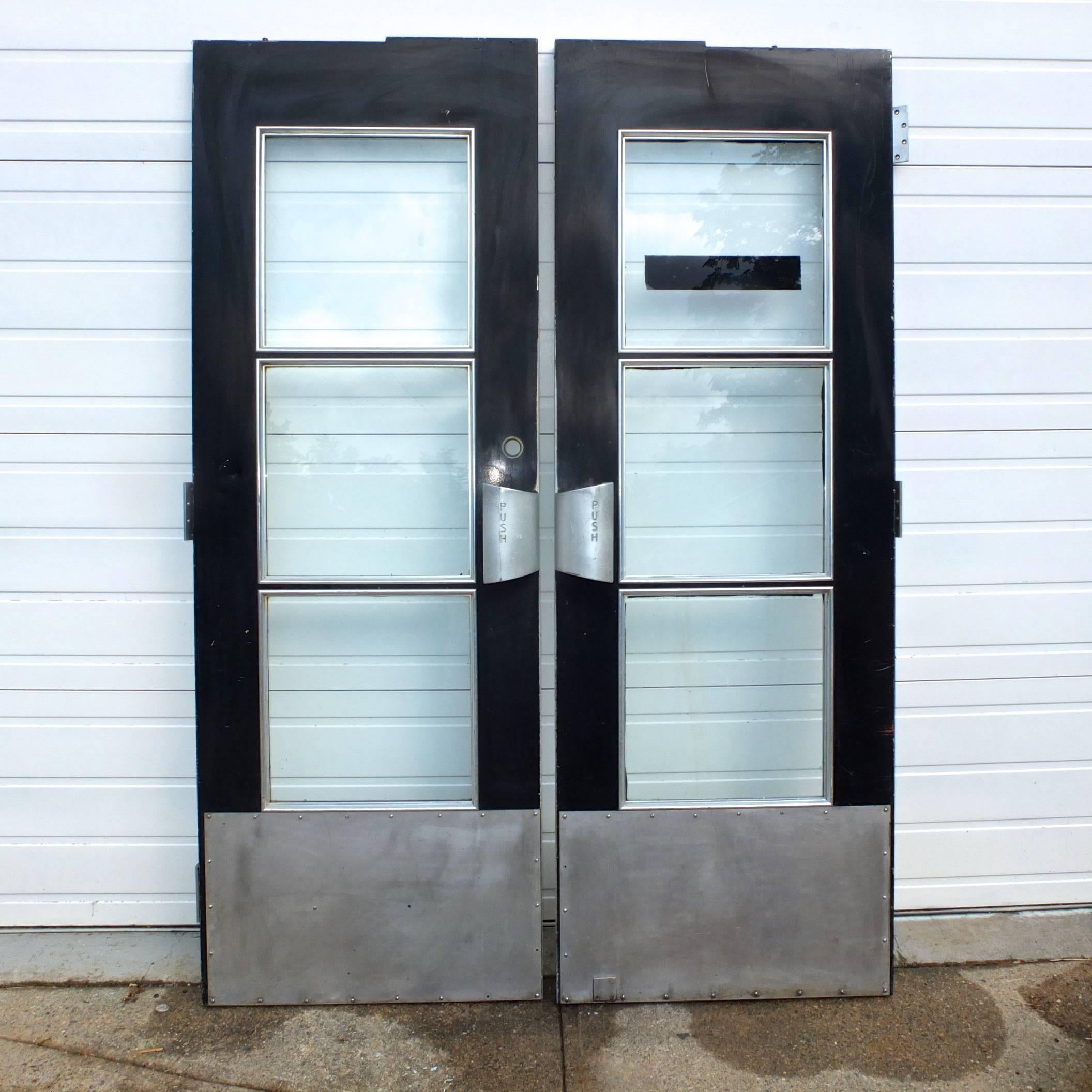 Pair of double doors made of aluminum and glass from the Gibbs and COX designed SS United States transatlantic ocean liner whose maiden voyage was in 1952. Streamline Art Deco styling. Heavy duty aluminum hinges and handles. Original paint and