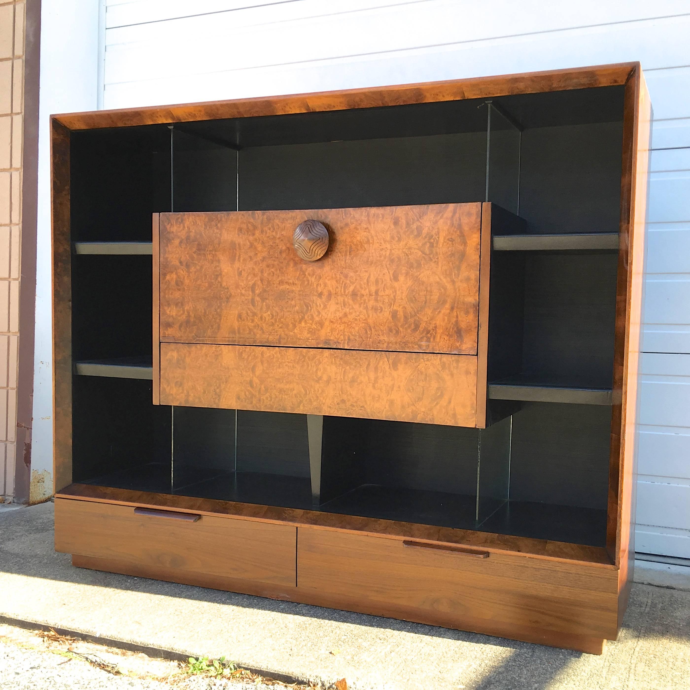 Gilbert Rohde large-scale bookcase with drop-front secretary desk and storage drawers in exotic burl paldao wood from his 1941 Paldao Collection for Herman Miller. 

Rohde's collaboration with Herman Miller (from 1932 until his death in 1944) is