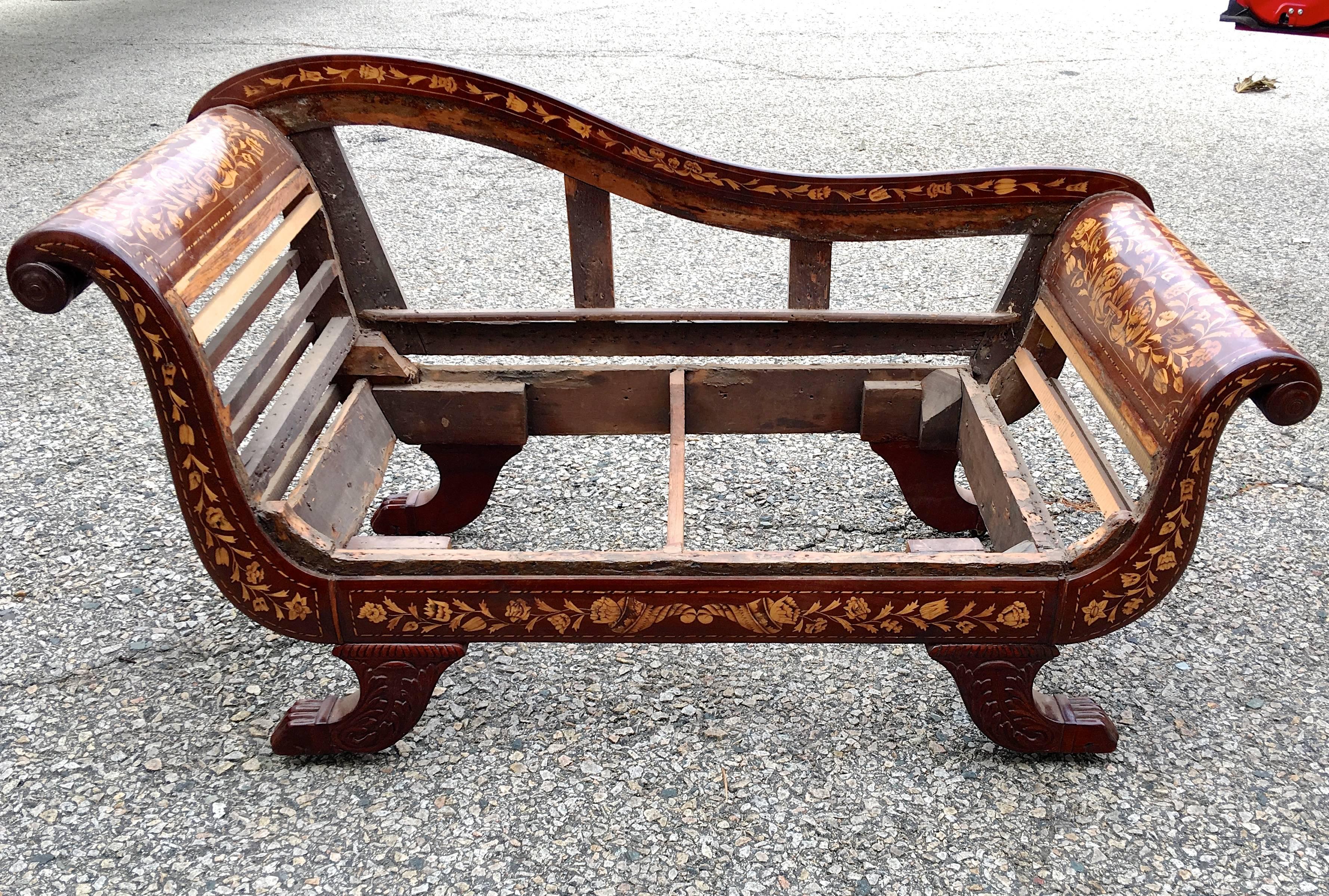 Stylized mahogany chaise settee handcrafted in Holland during the first quarter of the 19th century and inlaid with satinwood marquetry. Being offered undressed to show the age and nearly complete originality. Restored and ready for your