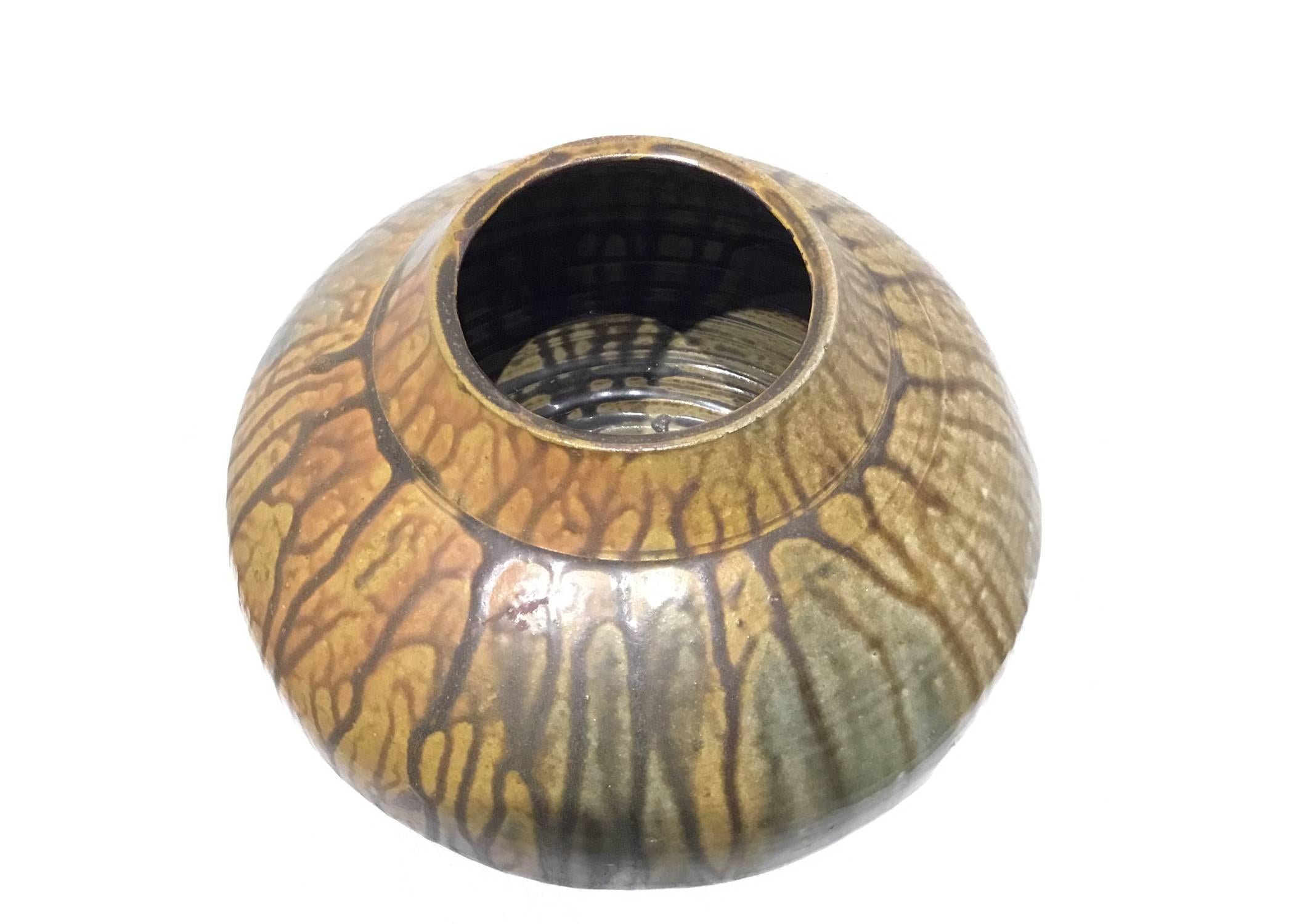 A large, heavy studio pottery vase with a drip glazed texture in tones of yellow, green and brown. Signed illegibly on the bottom.

1960s

Wear consistent with age.

Used items may have wear and/or flaws which the pictures cannot depict. All