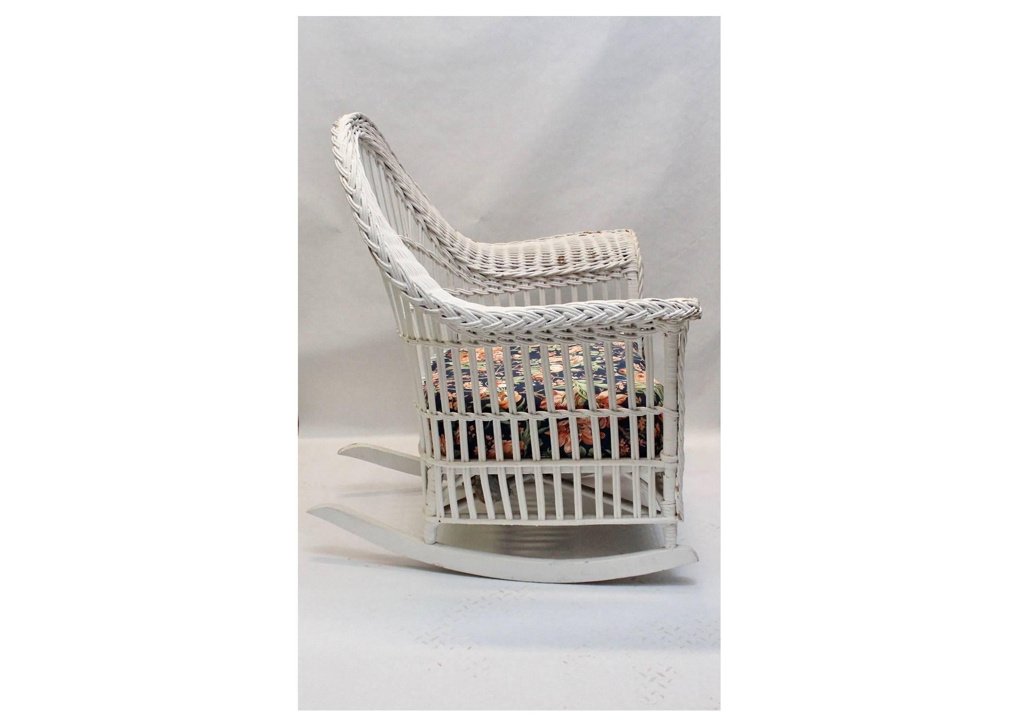White wicker rocking chair 
Floral print upholstered seat.