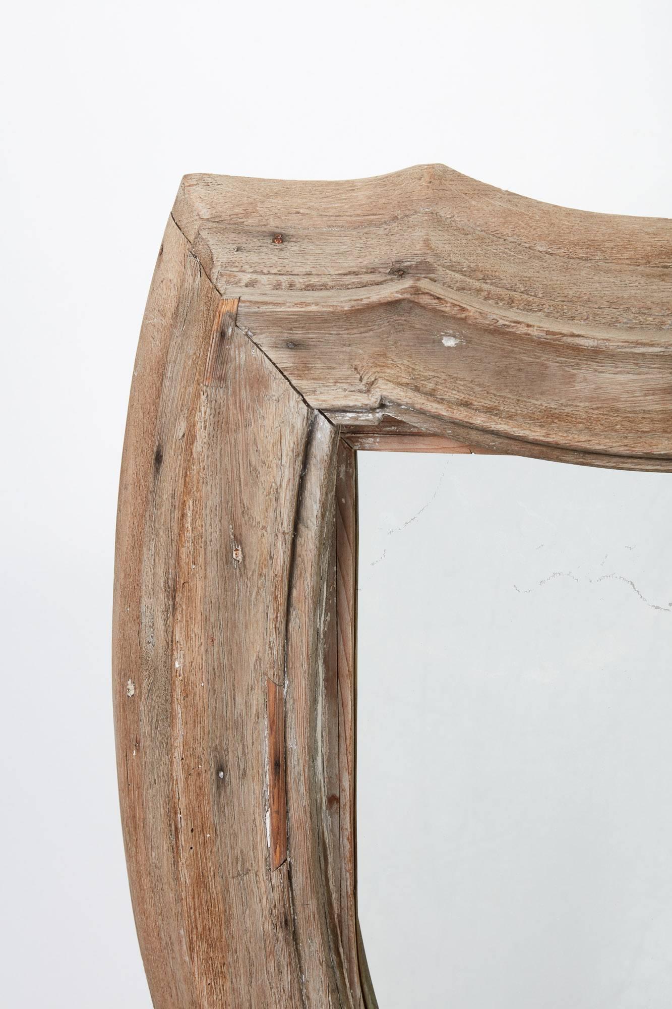 19th Century French Bleached Wood Mirror. Antiqued shield mirror. Weathered natural wood finish on the shield shaped frame. Mirror is in excellent condition.