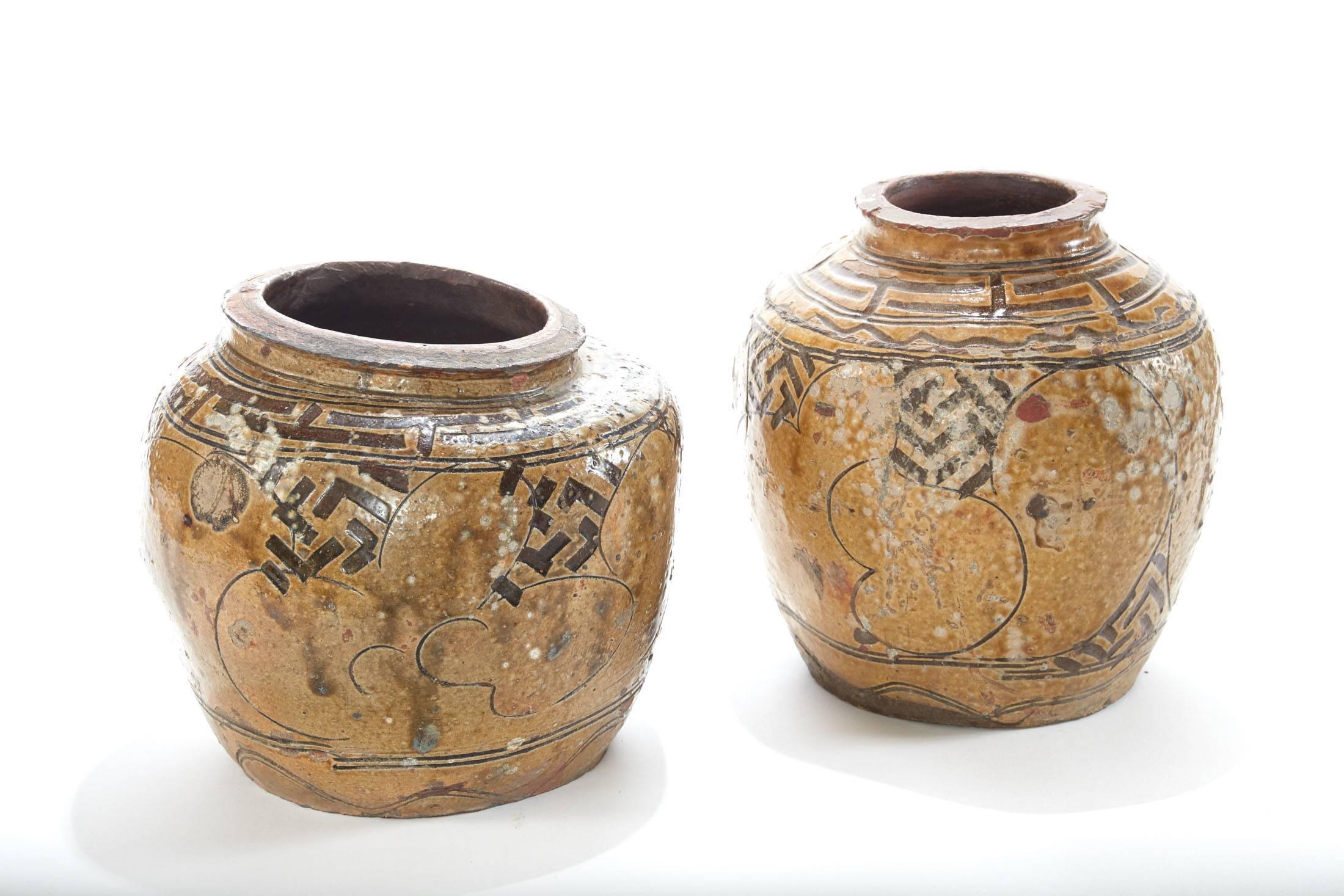 Two of a pair of 19th century glazed Asian pots 
Gorgeous worn and weathered patina
One was smashed during the process of fabrication and has an interesting shape as a result
sold individually but work well as a pair


Dimensions from left to