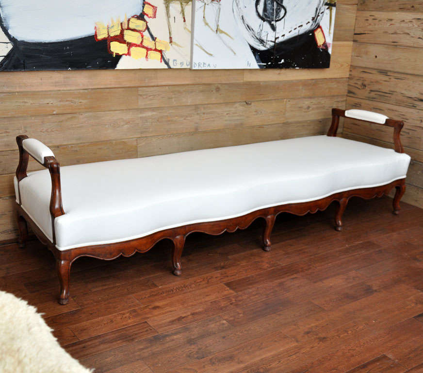 19th century French carved wood and upholstered bench
Unusual French bench or daybed with gracefully curving front and straight back side. Newly upholstered and new cushion in white cotton muslin
Measures: Arm height is 26