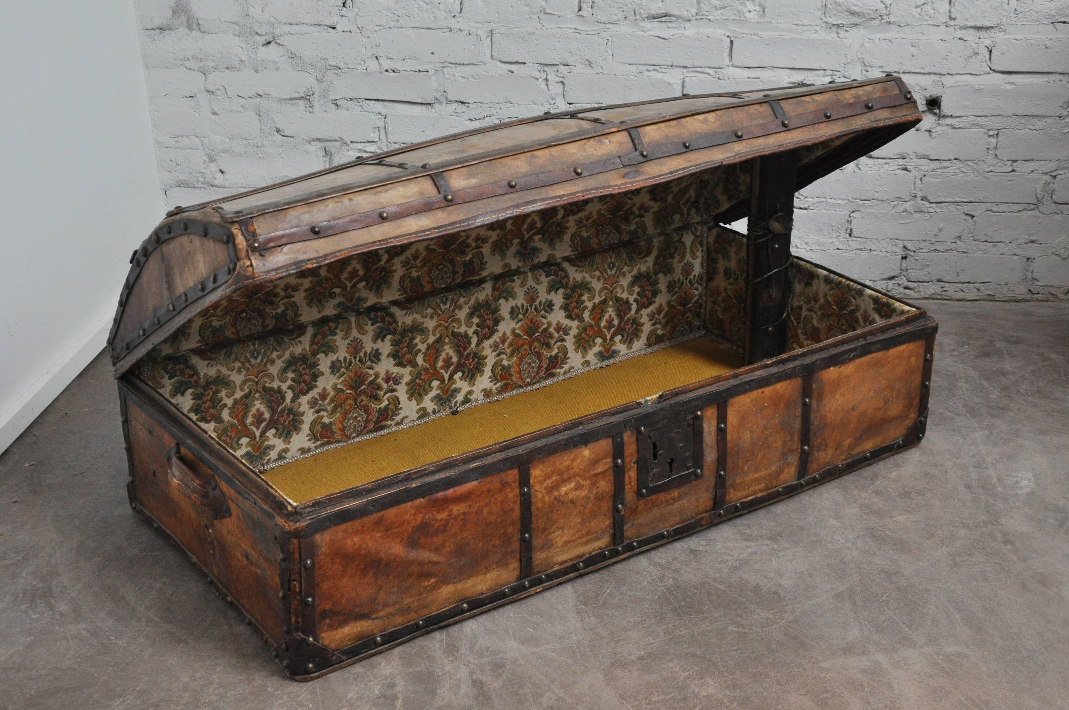 Early 20th century antique parchment and iron trunk. 
This trunk has a rounded top with fabric interior.
Forged iron details and lock.
Probably a travel trunk. Found in Spain.

Dimensions: 42.5