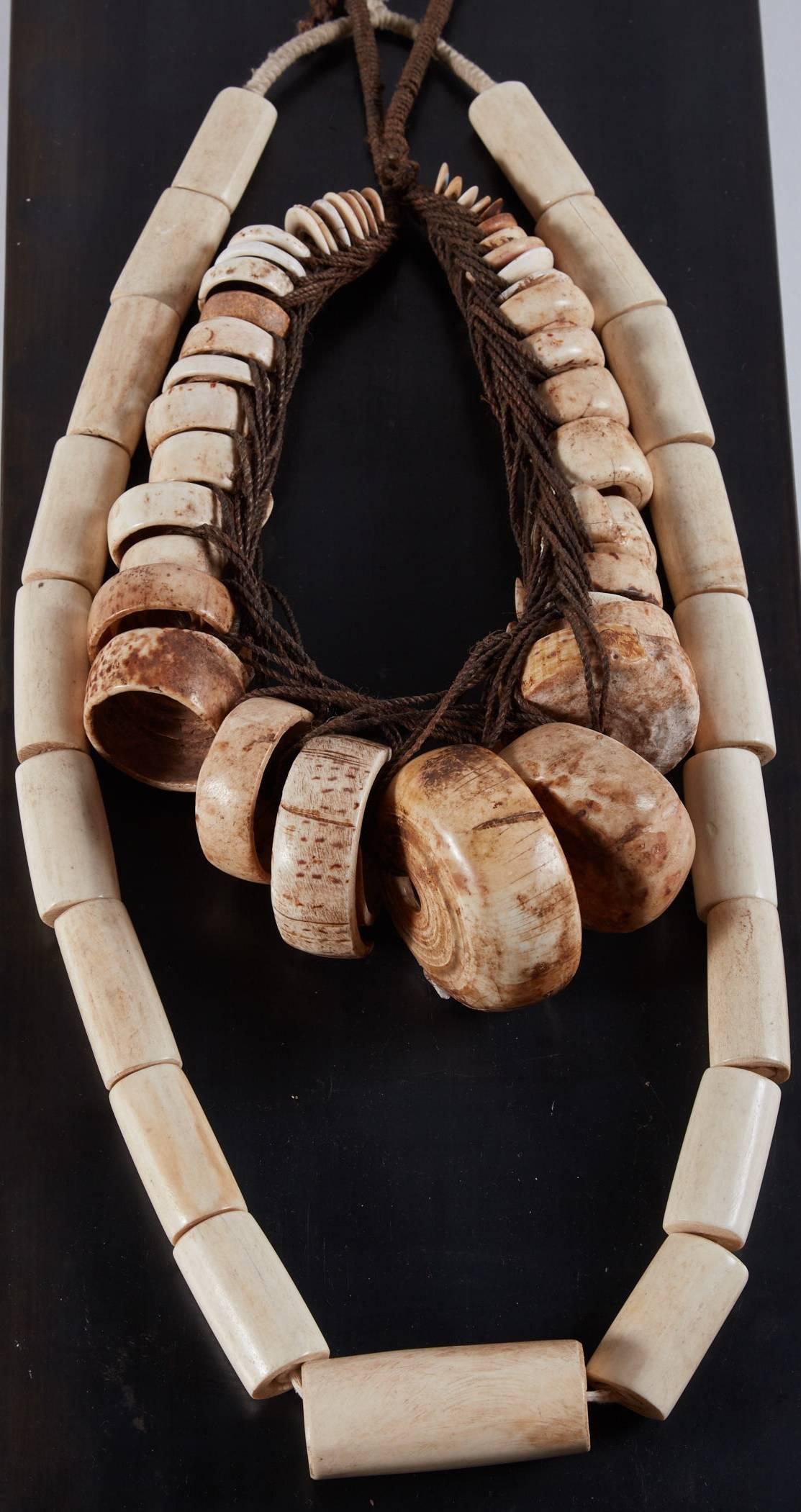 19th-20th century tribal bead objet d'Art 
20th century African bone bead strand 
19th century Thai Shell bead strand 
Displayed in steel and Lucite display case
Strands can be secured to steel and case can be adjusted to hang on the