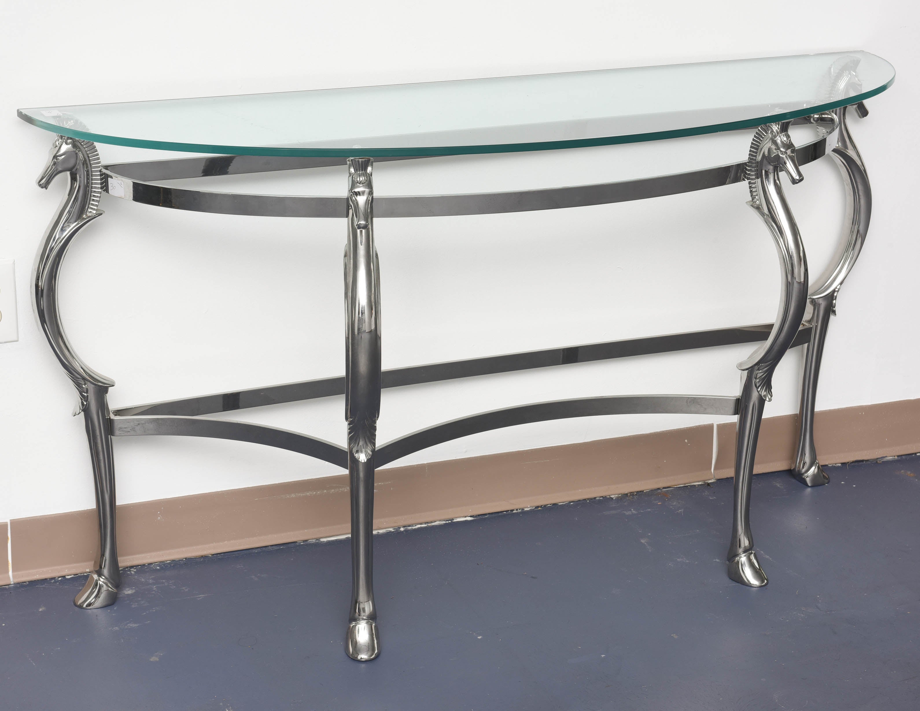 Glass and Chrome Mid-Century Modern elegant curved lines, horses heads on the legs supporting the thick glass top, this piece of furniture will match any style, the frame is in chrome metal.
