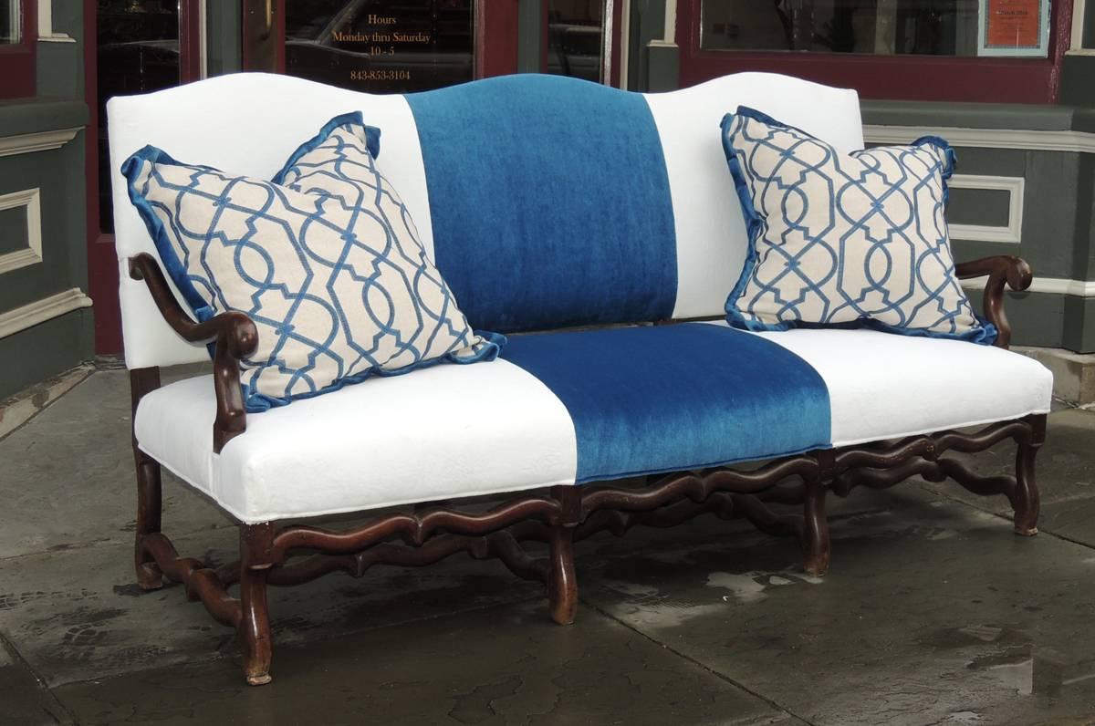 This French Baroque sofa was made in the late-18th century, circa 1770, and has modern blue and white fabric. The sofa is made of horsehair and has carved arms and a trestle base with eight legs. The two large pillows can be included.
 