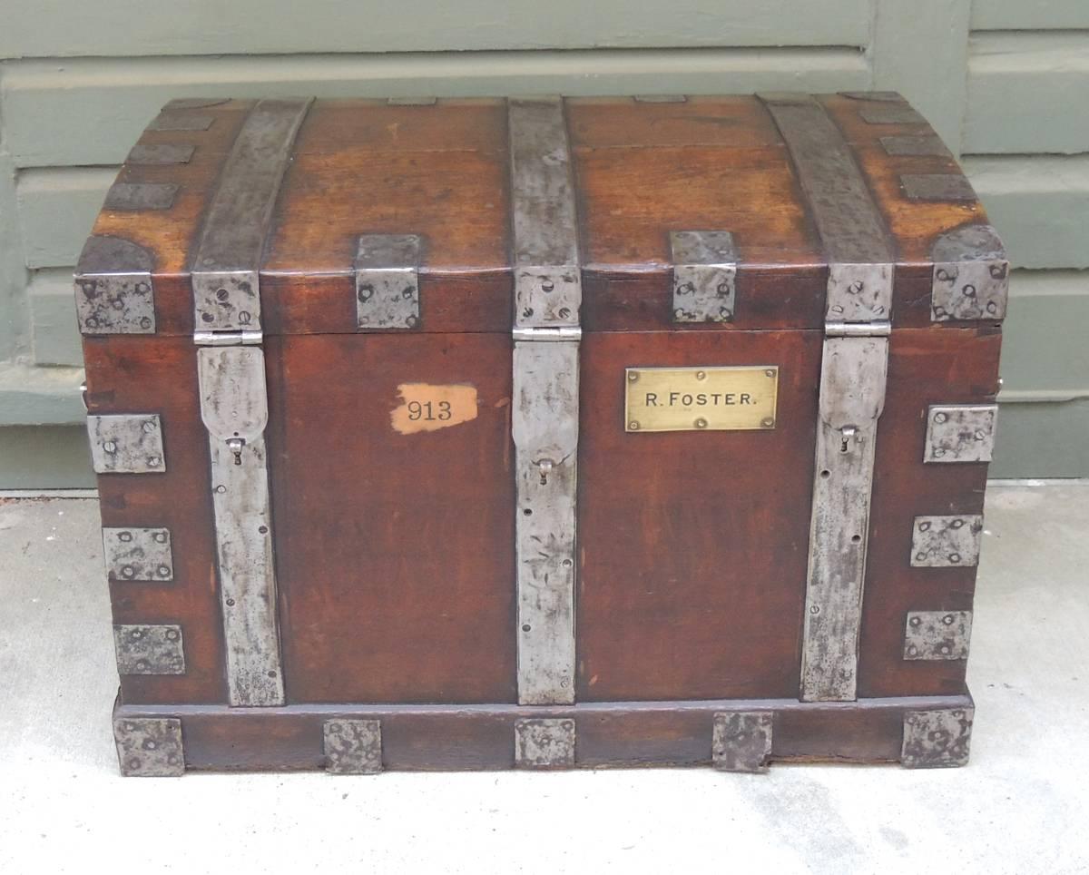 This silver chest was made in England in the mid-19th century, circa 1850, and is made of oak with exposed steel hinges and strapping. This trunk was created to hold a Mackay, Cunningham & Co silver collection and still bears their original label