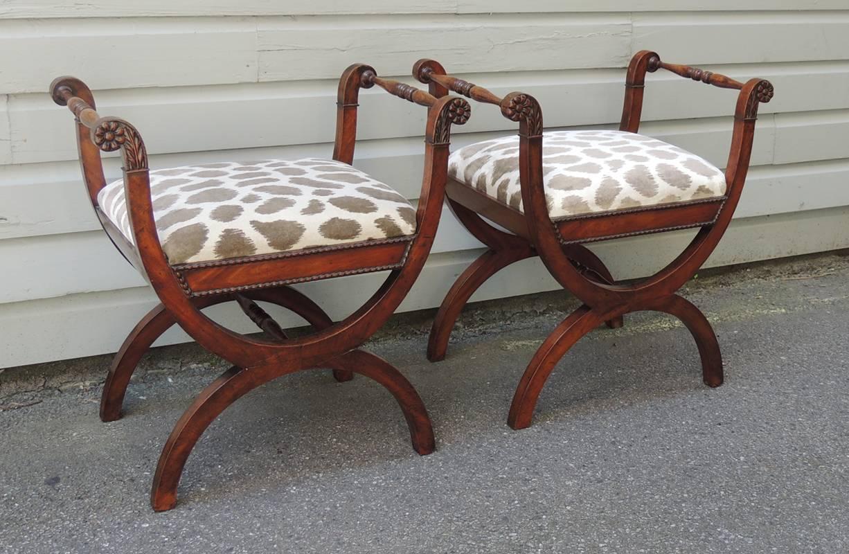 This pair of Italian benches were made in the 19th century, circa 1820s. This pair features curved arms with floral carvings has connected turned spindles. The slip in seats are covered in animal print upholstery surmounted on beaded edge detailing.