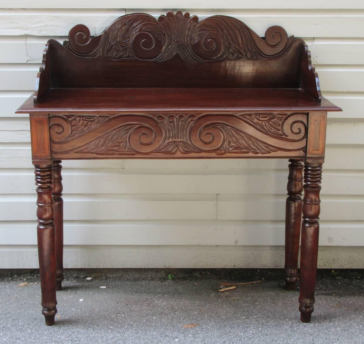 This Caribbean solid mahogany with satinwood inlay vernacular sideboard is made in Jamaica, circa 1820-1840. It is one of the Rare Jamaican Regency Sideboards that exhibits an unusual exuberant carved frontal frieze with the decorative motif echoed