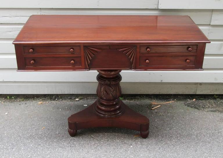 A rare West Indies regency serving table, circa 1820, featuring five drawers (four side and one center drawer with fan carving) and tulip pedestal base with acanthus carvings and bun feet. This Regency Jamaican Server shows all of the highest