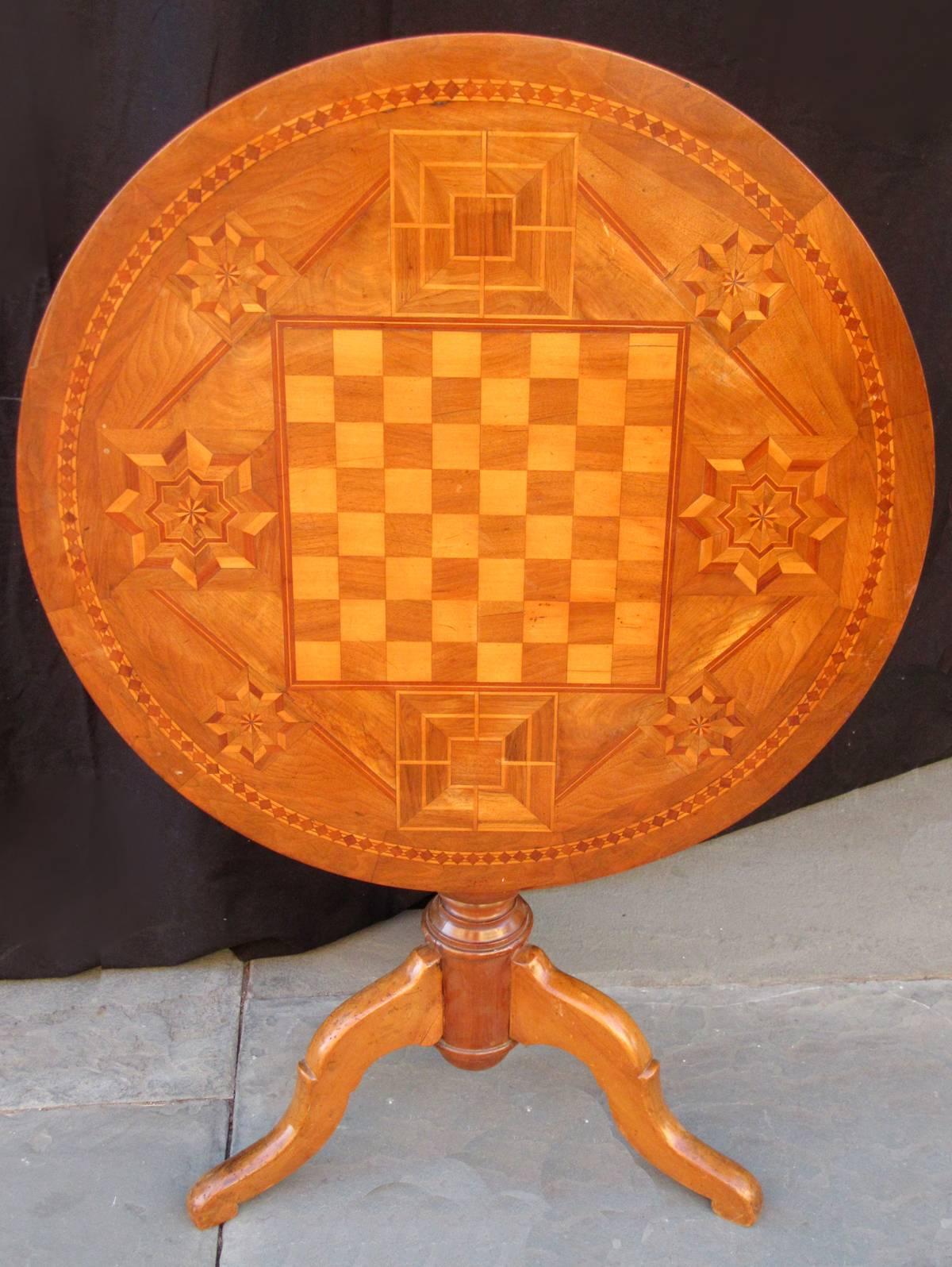 An Italian walnut tilt top table on a pedestal base, circa 1840, with chess board inlay top.