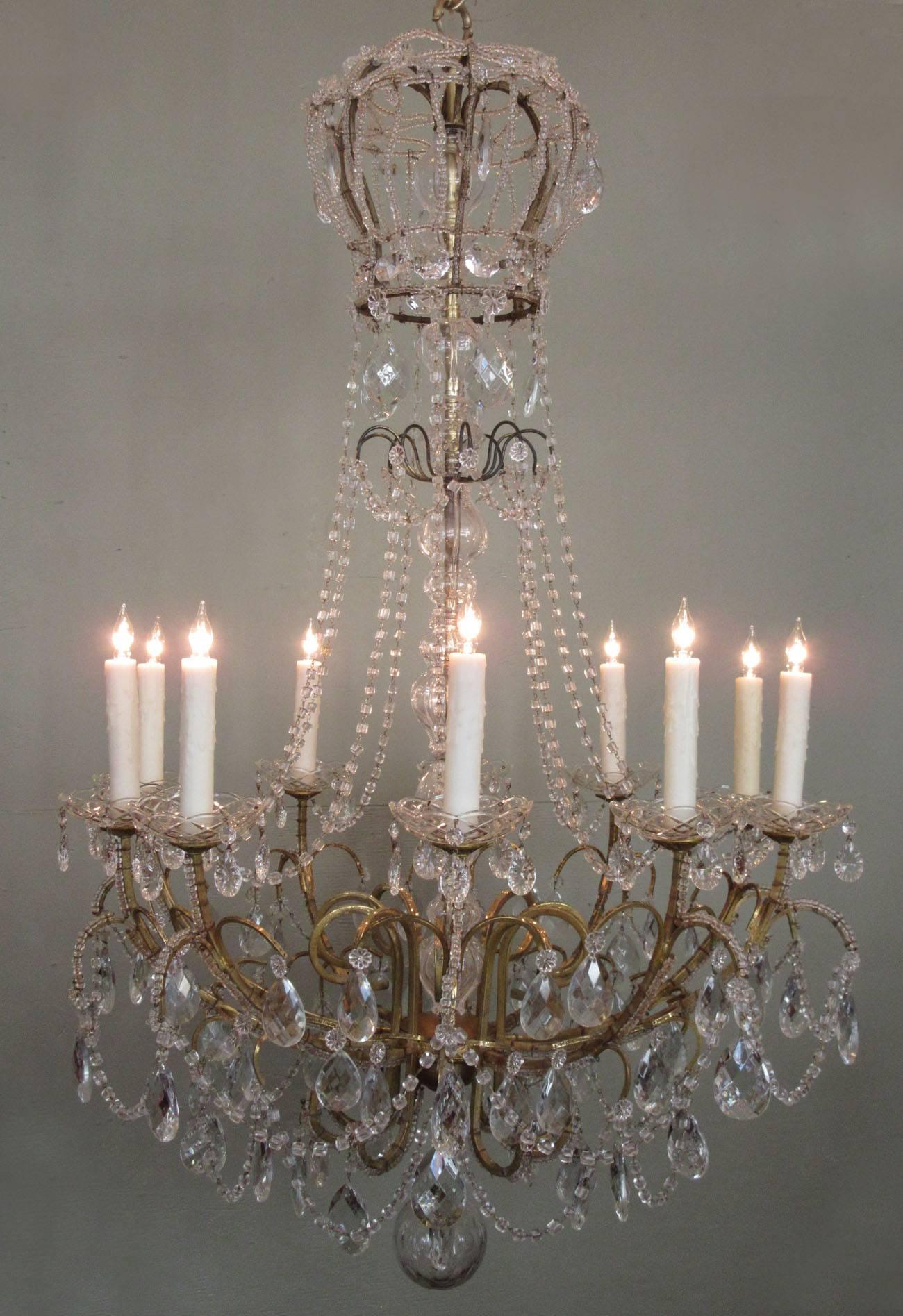 A stunning Italian brass and crystal chandelier, circa 1900, featuring a crystal beaded crown, ten candle arms with crystal bobeche and crystal beaded swag and pendants. The chandelier has recently been cleaned and rewired with new porcelain sockets.