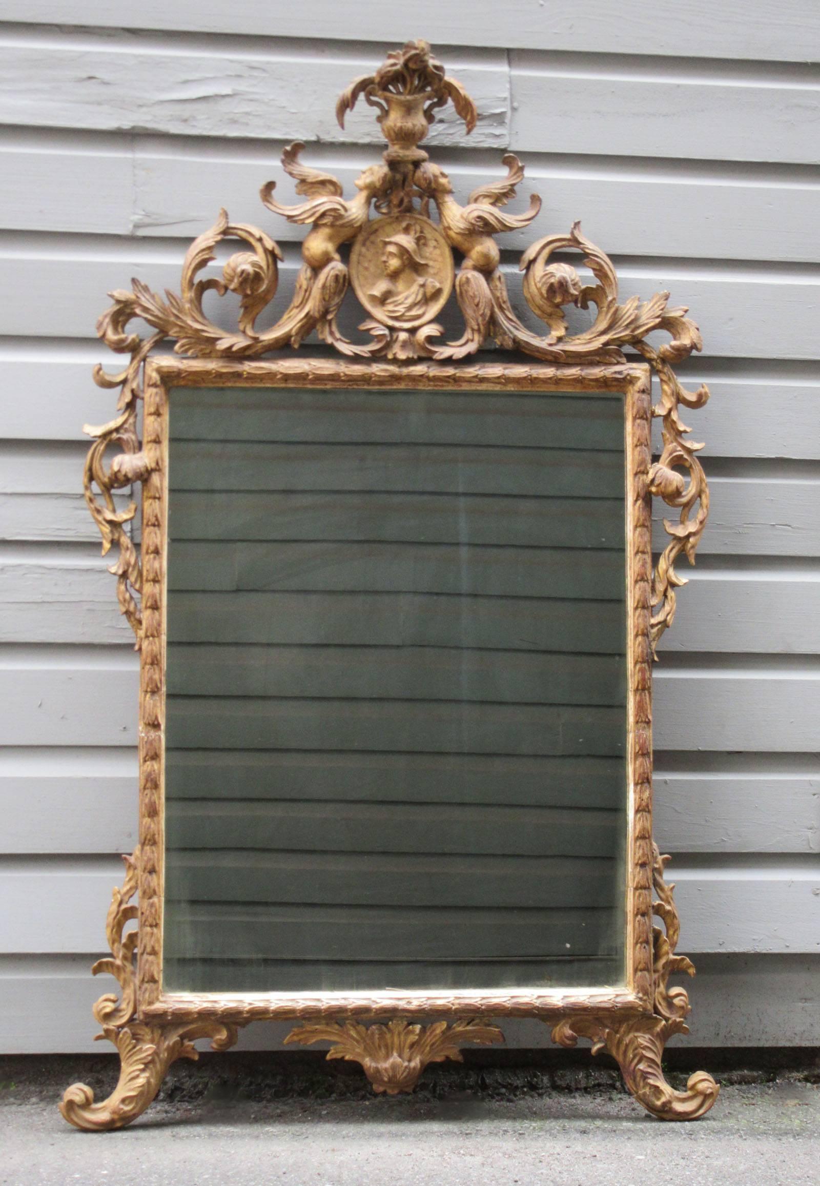 A stylish Italian Rococo carved giltwood mirror, circa 1780, in the Chinoiserie taste and featuring Venetian carved motifs.   