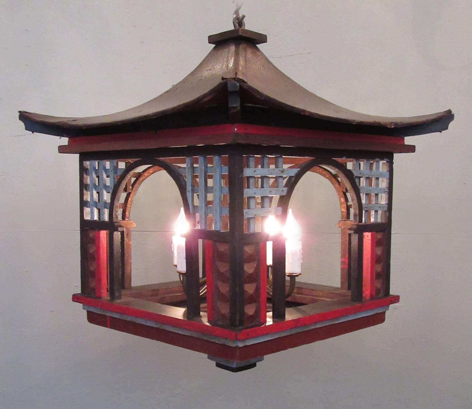 A charming pagoda lantern made in France, circa 1920, made of painted wood and papier mâché and featuring four candle bulbs. The lantern has been recently rewired with new porcelain sockets.