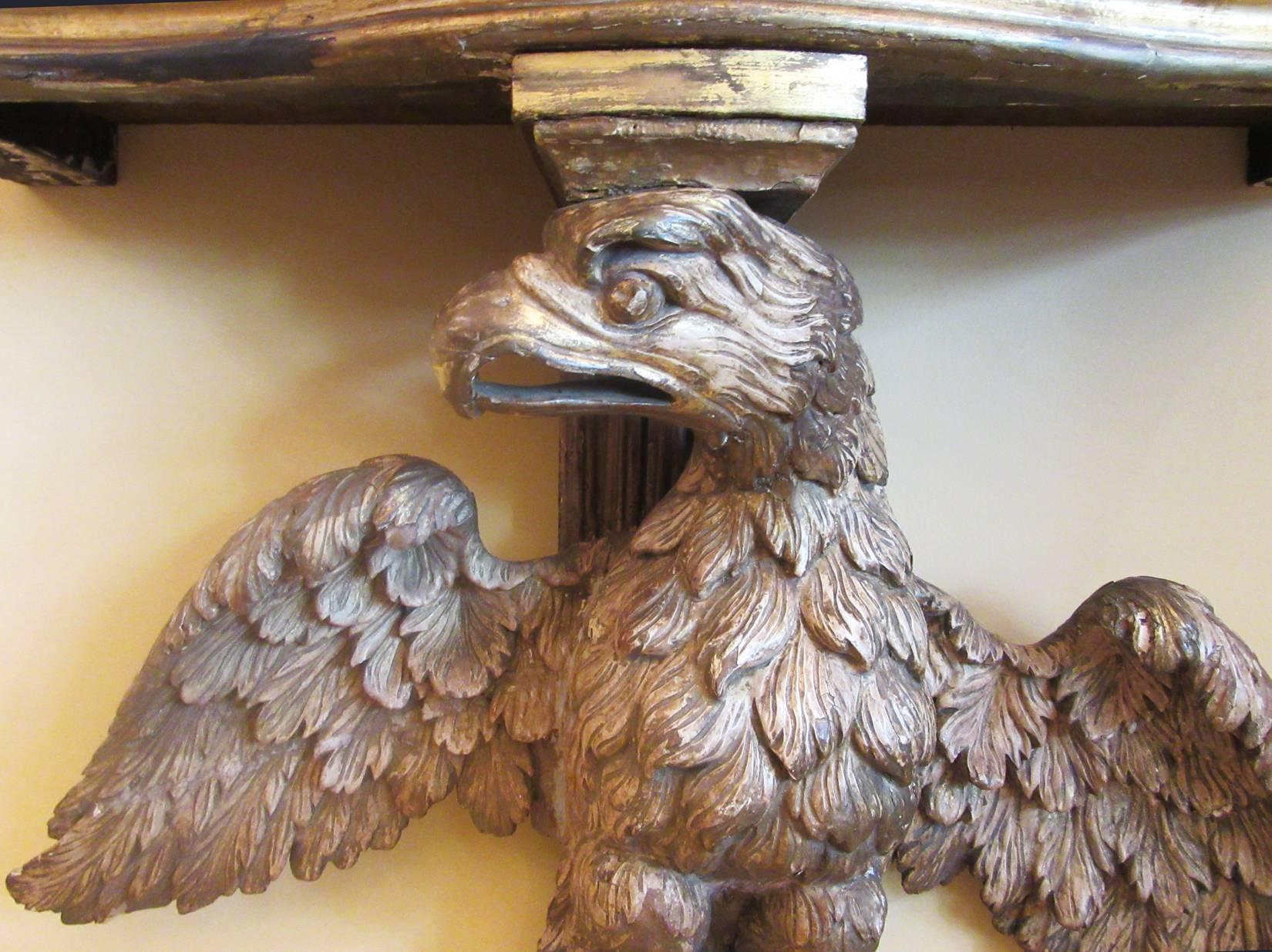 A finely carved mid-18th century English Georgian console table, circa 1750, with a rose marble-top and base featuring a displayed eagle on a plinth. This table has been attributed to William Kent.