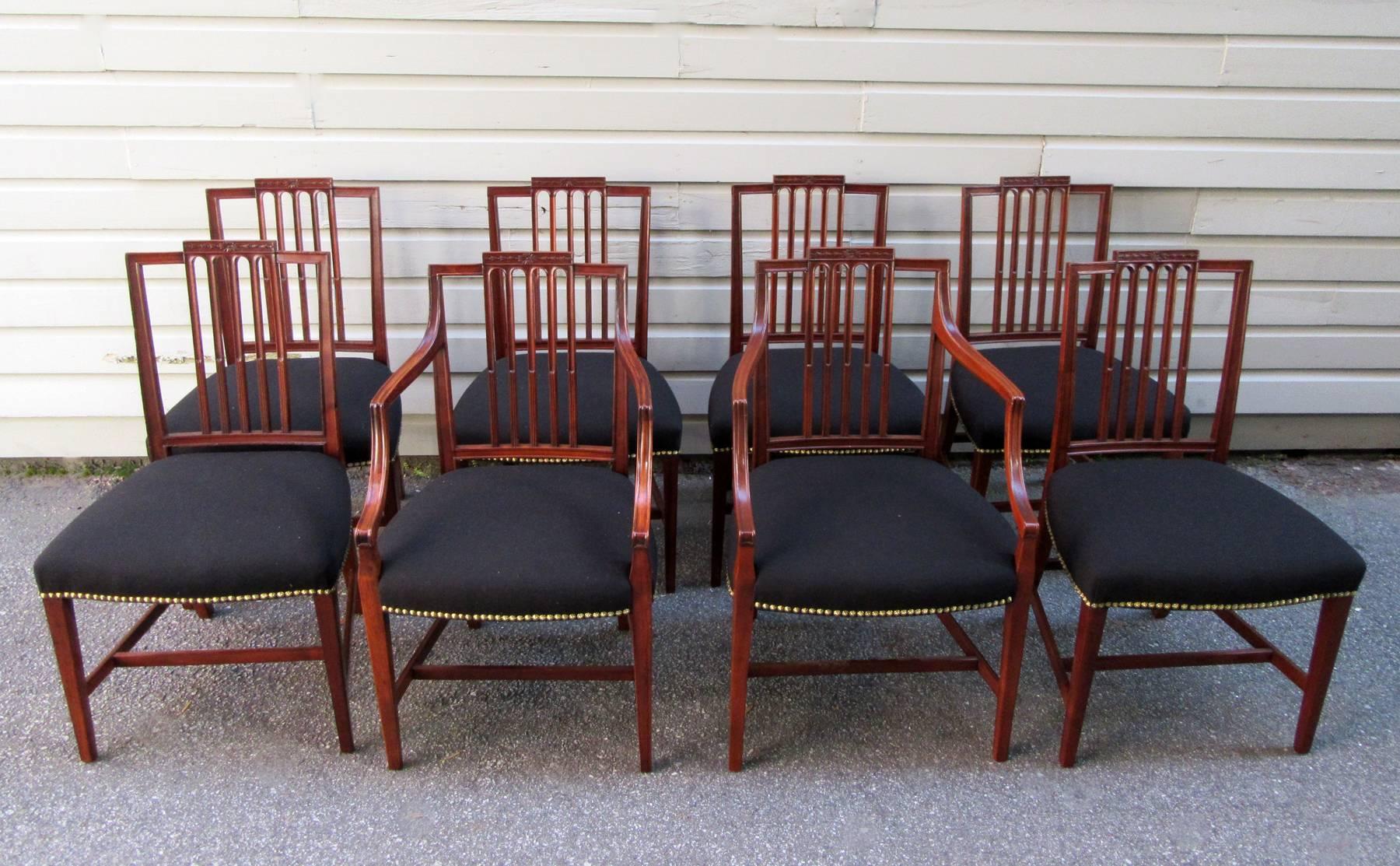 A fine set of eight Hepplewhite mahogany dining chairs made in England, circa 1790, with two armchairs and six side chairs featuring new black brushed cotton upholstery finished with nail head trim. One of the side chairs is a reproduction made in