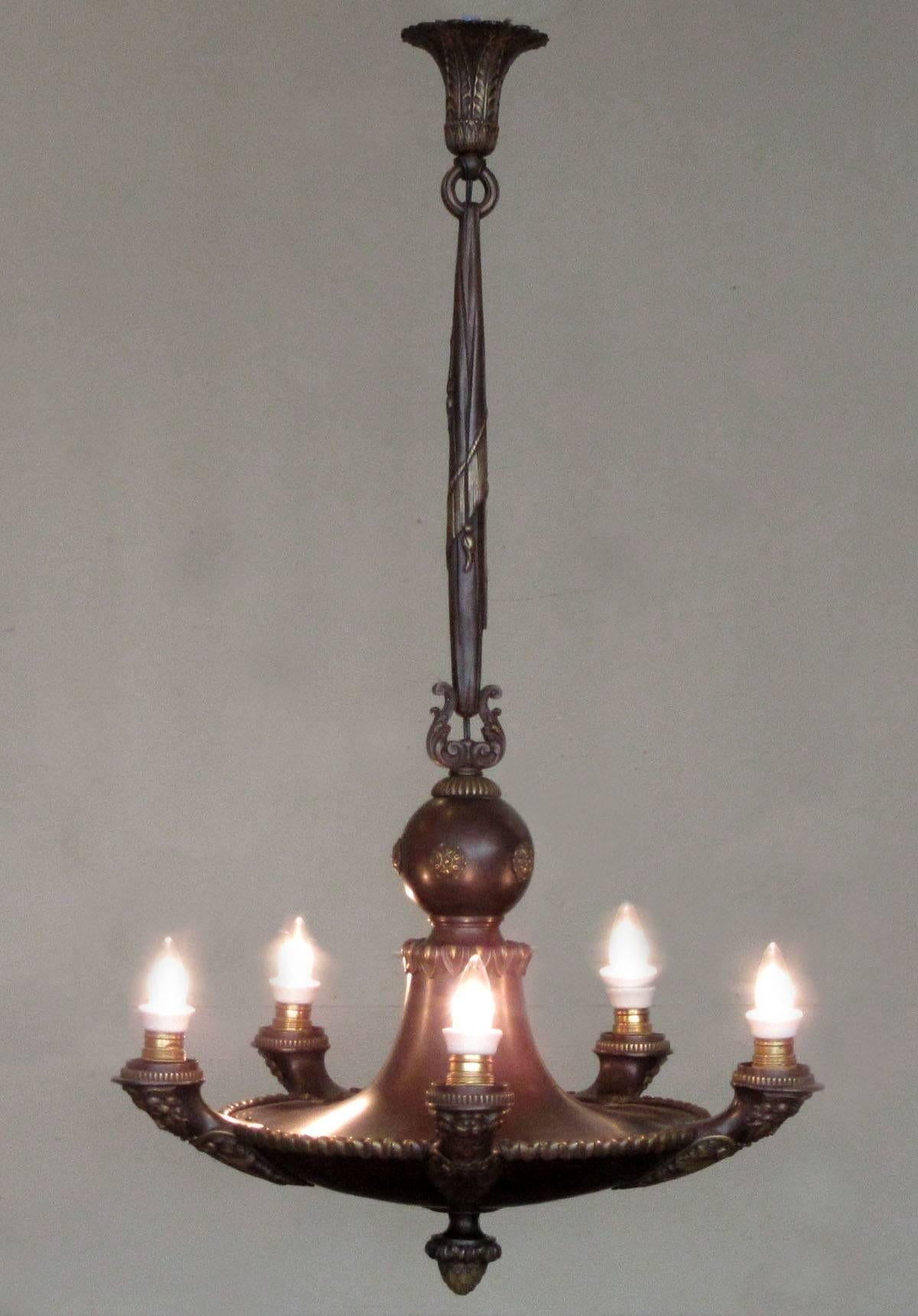 A French Empire bronze gasolier, circa 1840, with patinated finish featuring six arms with neoclassical castings. The chandelier has been converted to electricity and has been newly rewired with porcelain sockets.