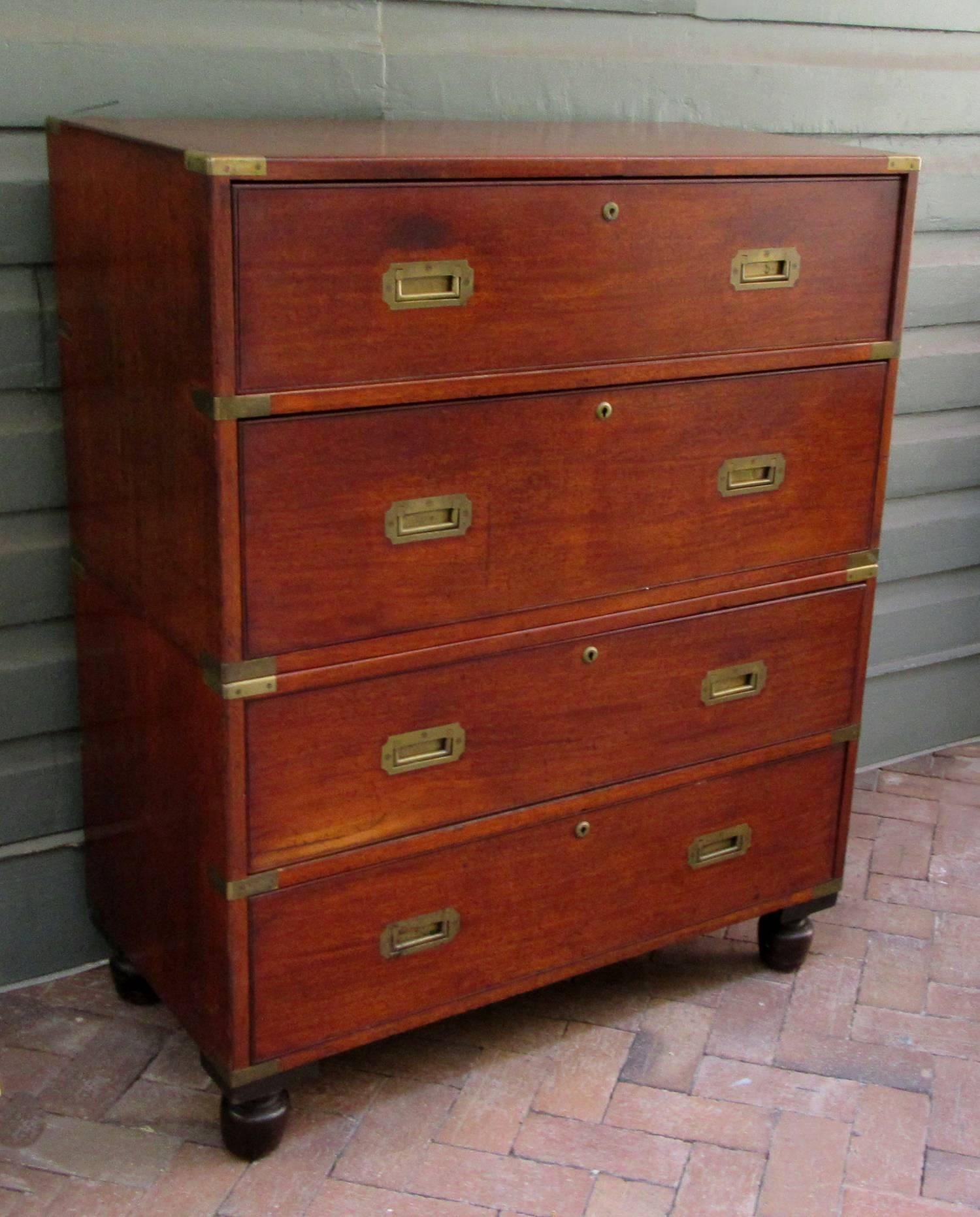 A mahogany English Campaign butler's desk, circa 1820, featuring two drawers with embossed black leather desktop and original turned bun feet.