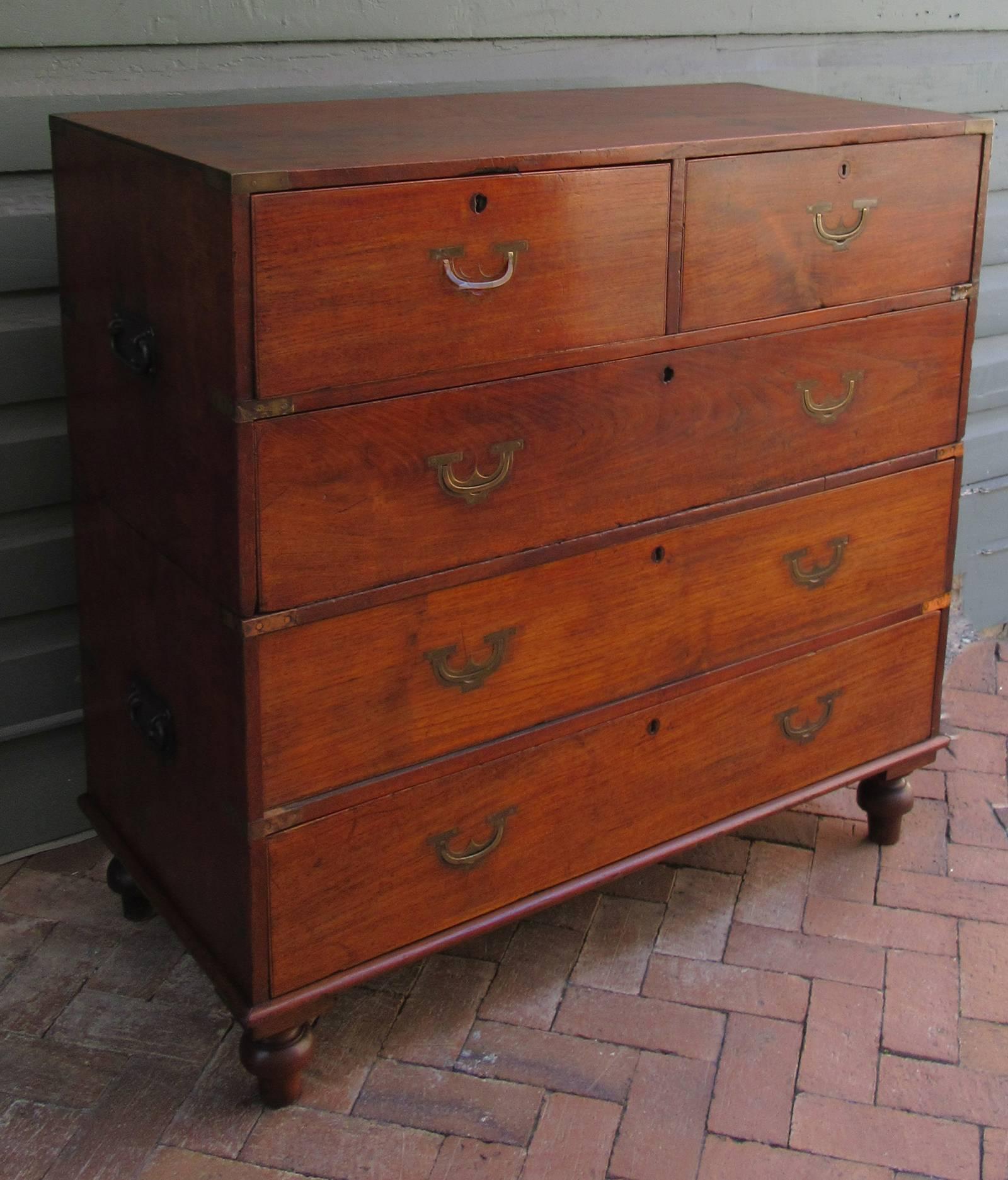 An English Campaign chest of drawers, circa 1840, in a 2/3 drawer configuration and made of mahogany. The feet are original to the chest and the chest is structurally in good condition; however, there have been several repairs to the brass banding