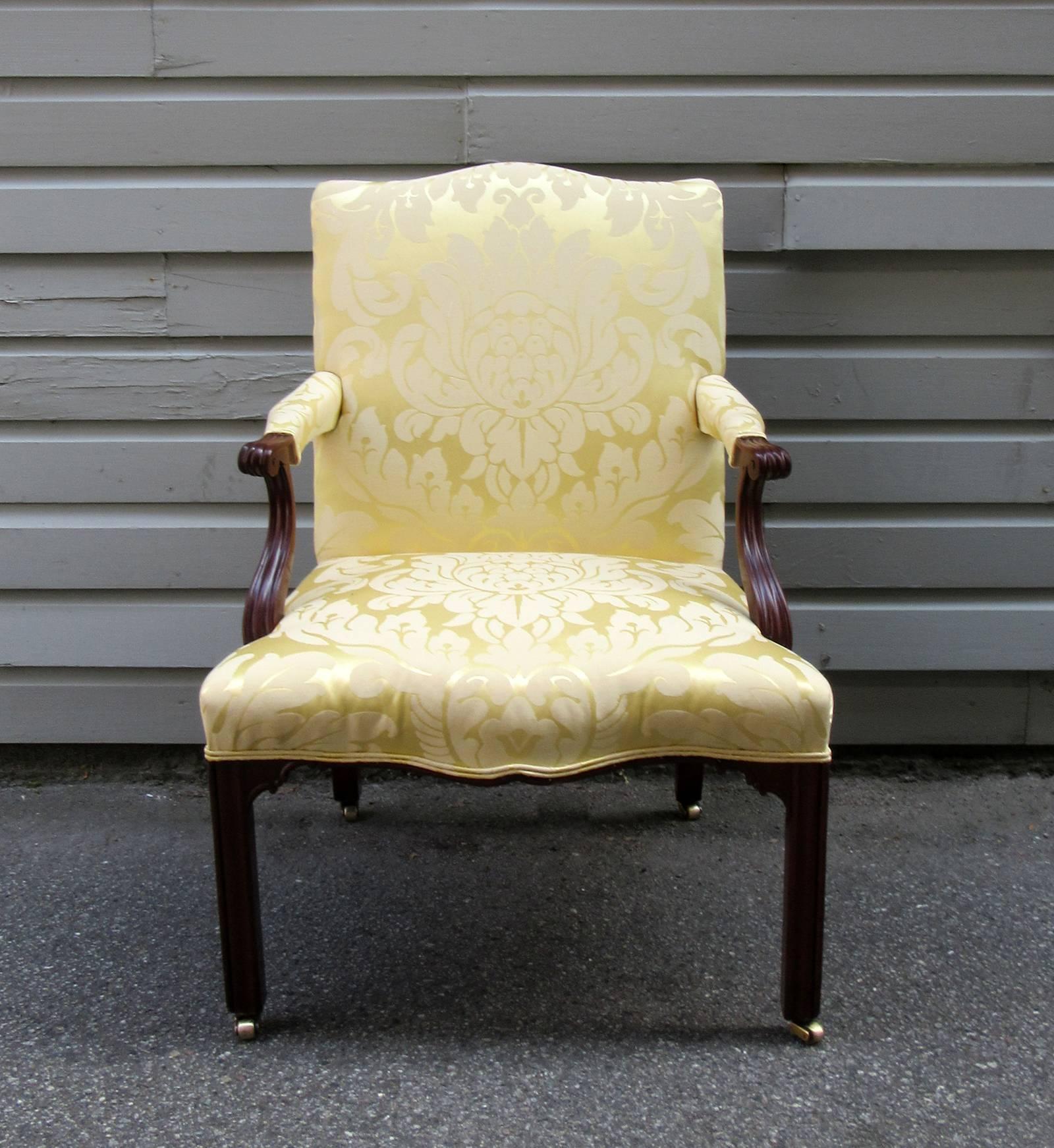A very fine English Chippendale mahogany open armchair, circa 1760, featuring Marlborough leg, Chinese brackets, grooved arms and new yellow damask upholstery. The casters are new.