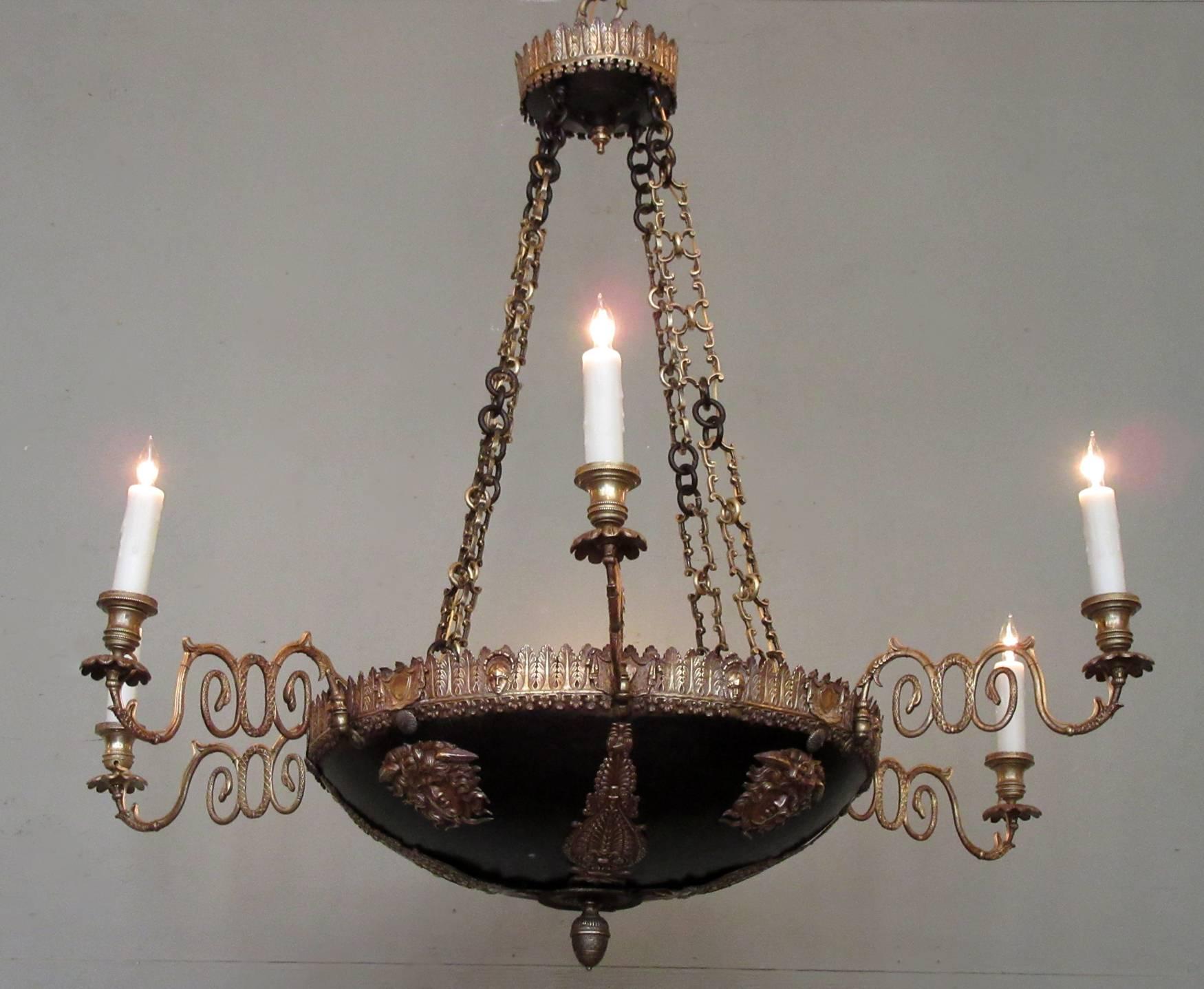 This dramatic chandelier was made in Italy in the late-18th century, circa 1780, and features a canopy bordered with acanthus leaves that has three supporting chains. The bowl of the chandelier is patinated bronze with applied bronze neoclassical