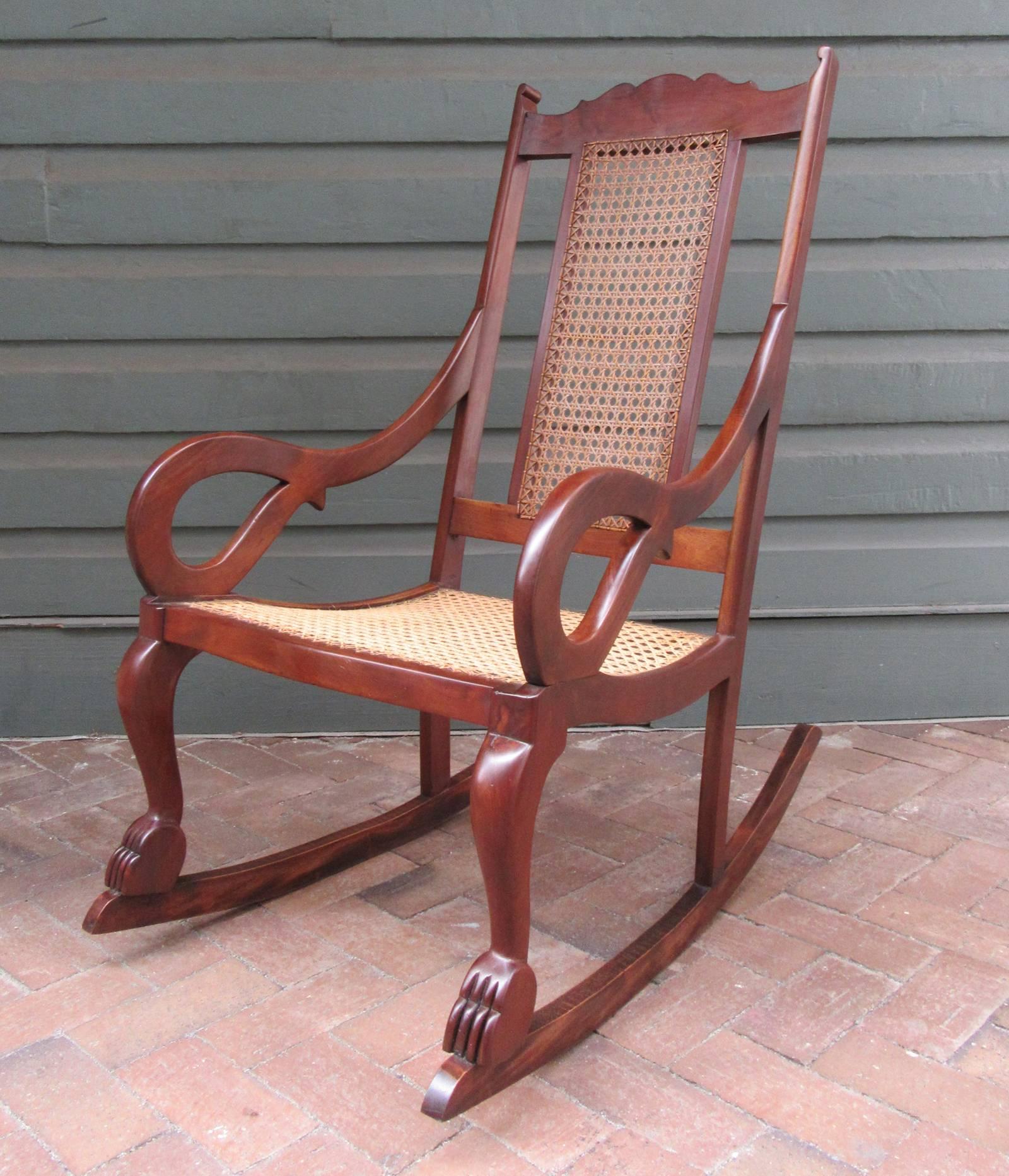 Sedia a dondolo Regency del XIX secolo in mogano e canna di St. Croix, 1820 circa, con braccioli a voluta, piedi a zampa e canne intrecciate a mano.