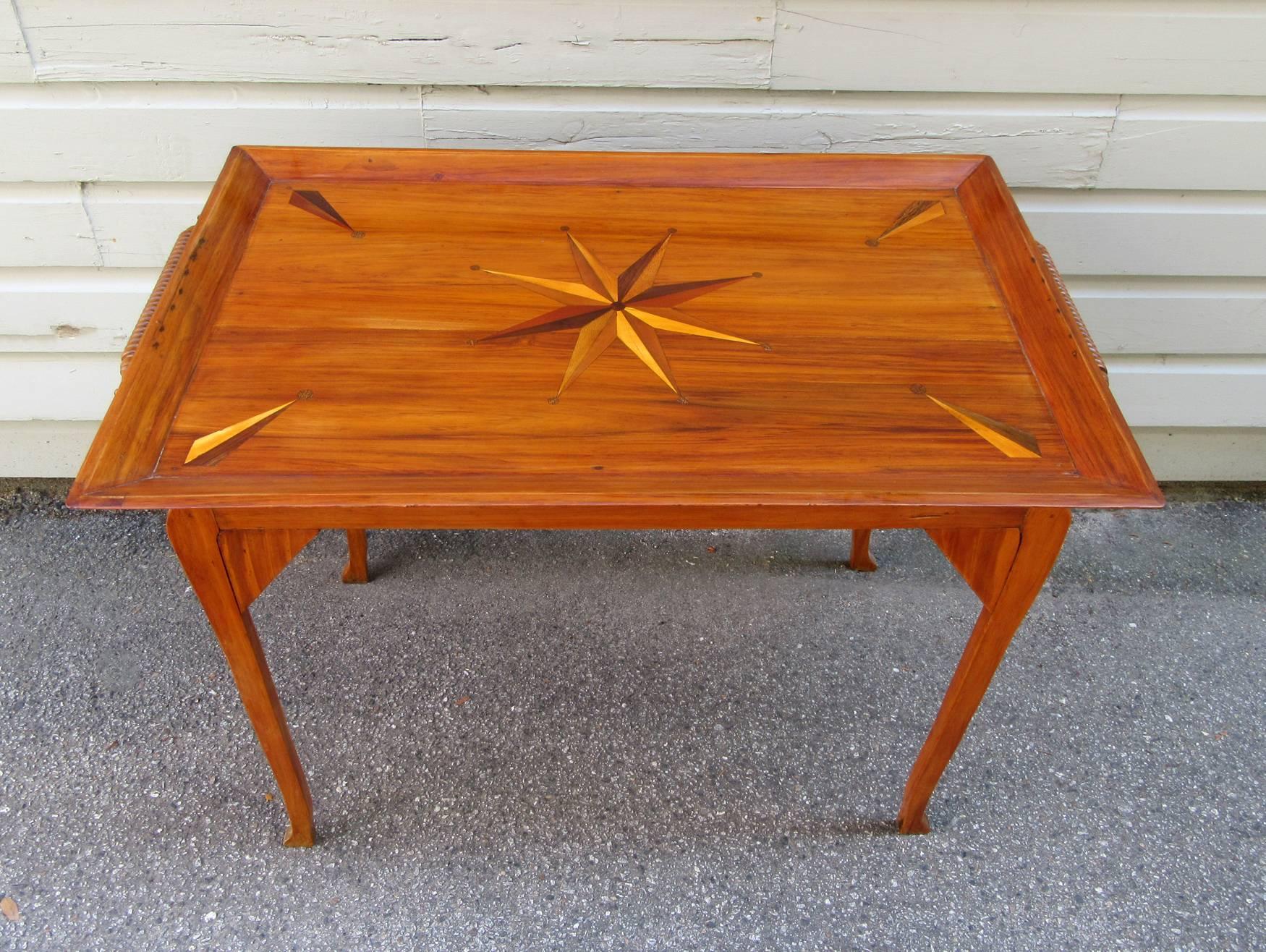 A solid 19th century Jamaican Regency yucca tray table with matching stand, circa 1840, featuring a tray top with compass shaped exotic wood specimen inlay and finely turned spooled rolling pin handles.