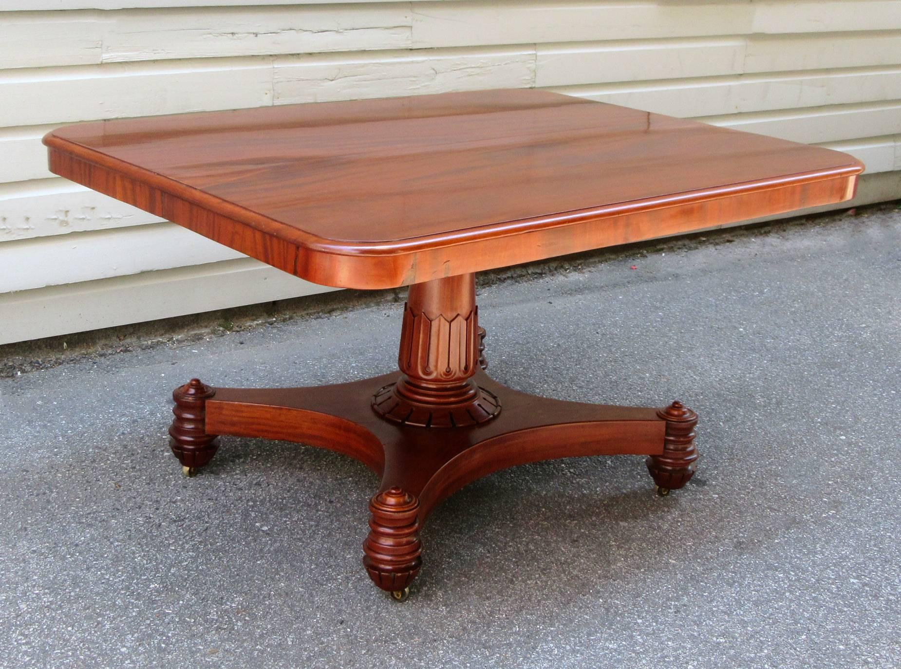 An early 19th century English mahogany tilt-top breakfast table, circa 1815, with classic Regency lines and featuring an Egyptian motif carved pedestal base.