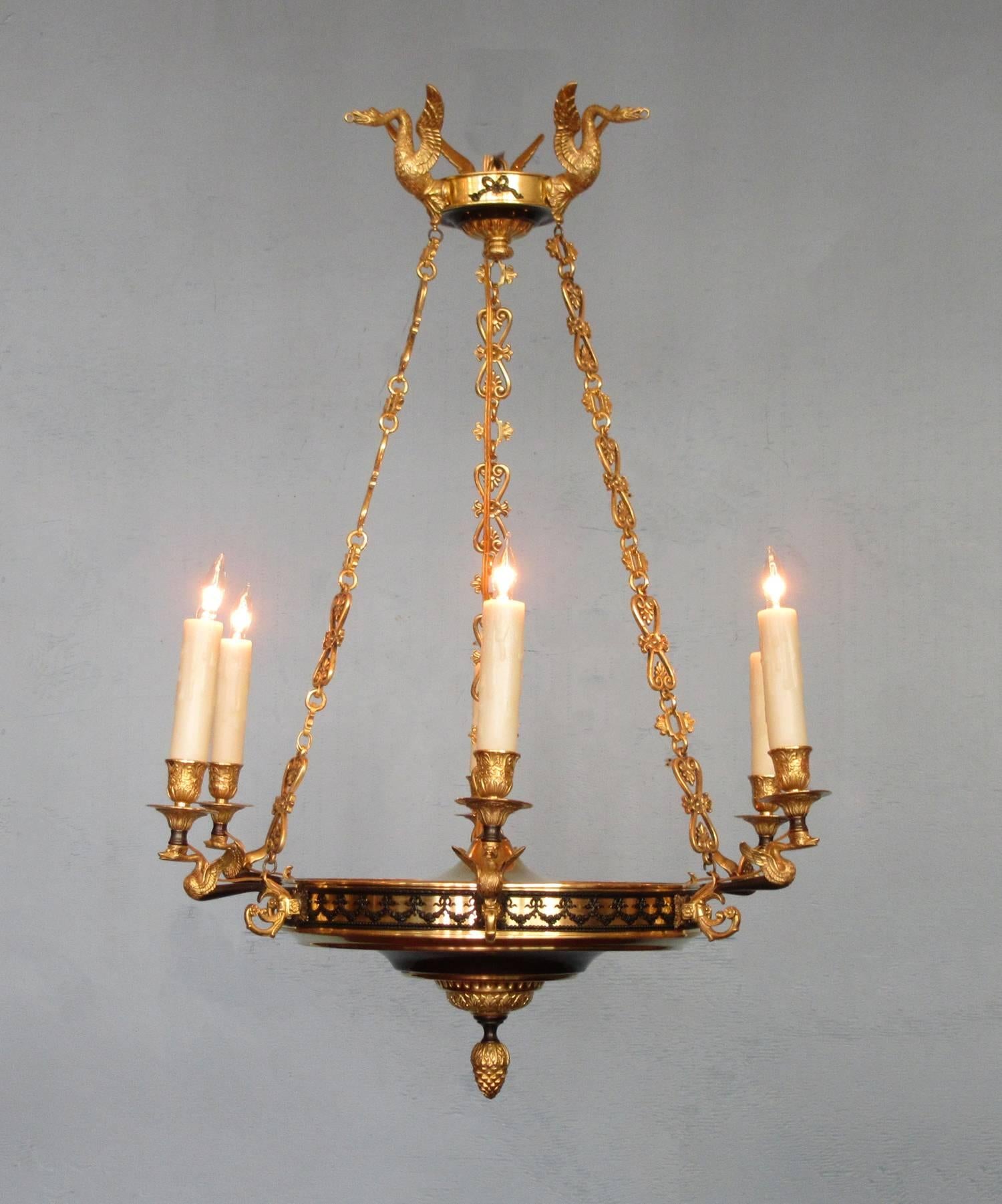 An early 19th century French restoration chandelier, circa 1820, featuring six candle arms, patinated and gilded bronze body adorned with finely detailed displayed swans. The chandelier was originally candle but has recently been cleaned and rewired
