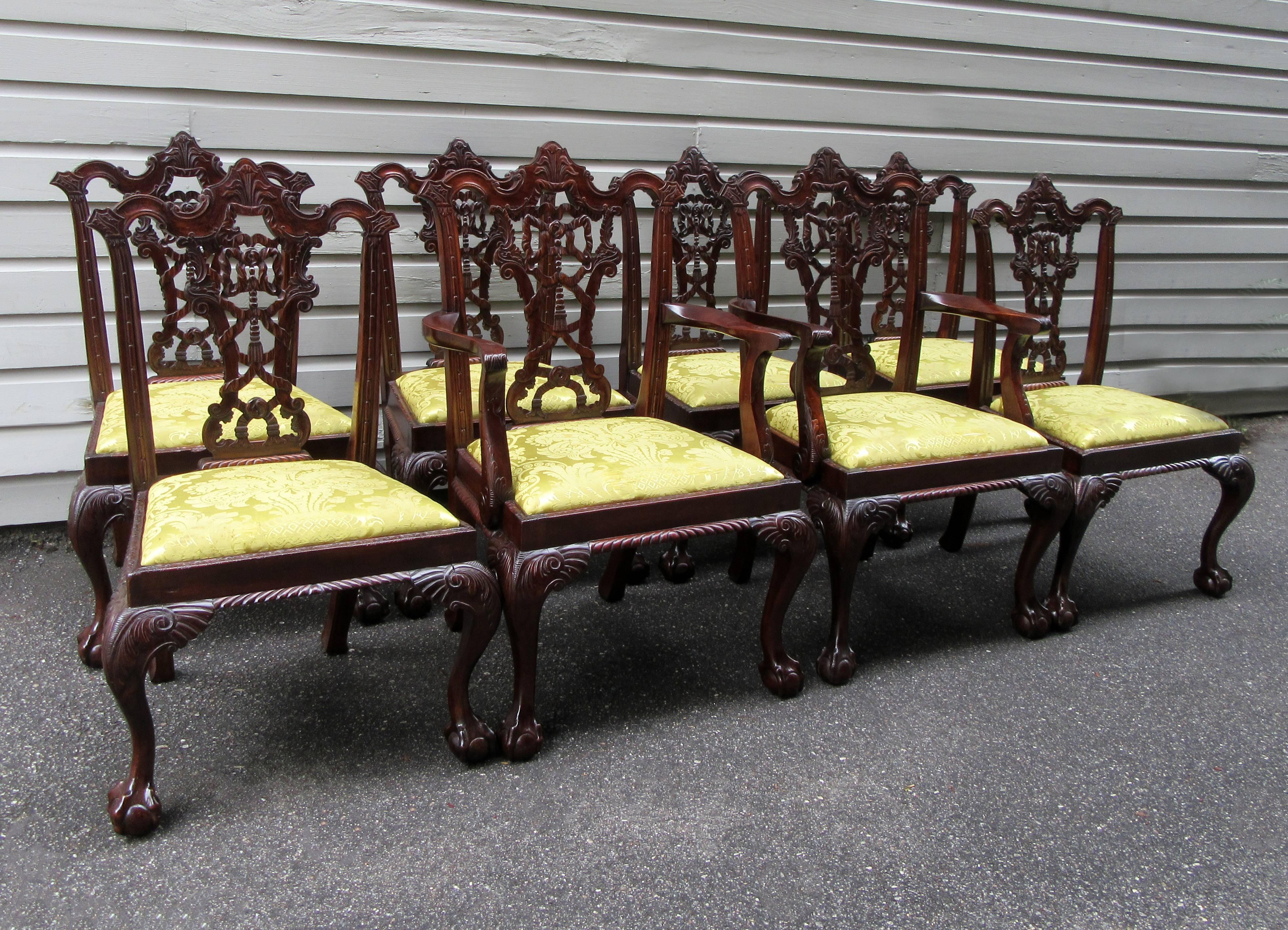 A set of eight English Chinese Chippendale mahogany dining chairs, circa 1900, featuring finely carved ribbon and tassel backs, claw and ball feet and chartreuse silk damask upholstered seats. The upholstery is in good condition but still very