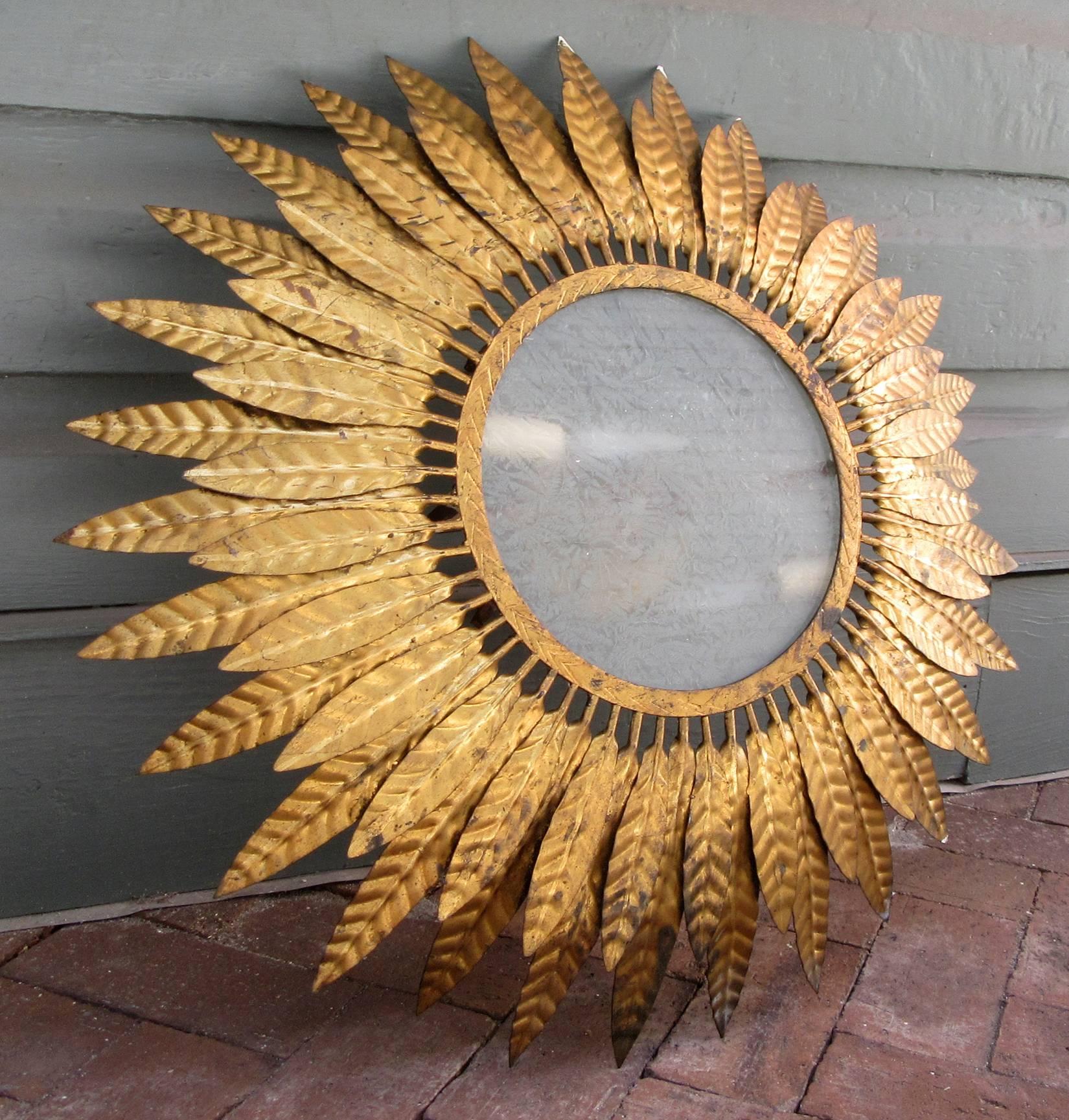 A substantial 20th century Spanish Barcelona style sunburst flush mount chandelier, circa 1920, featuring displayed gilt tole leaves and frosted glass panel.