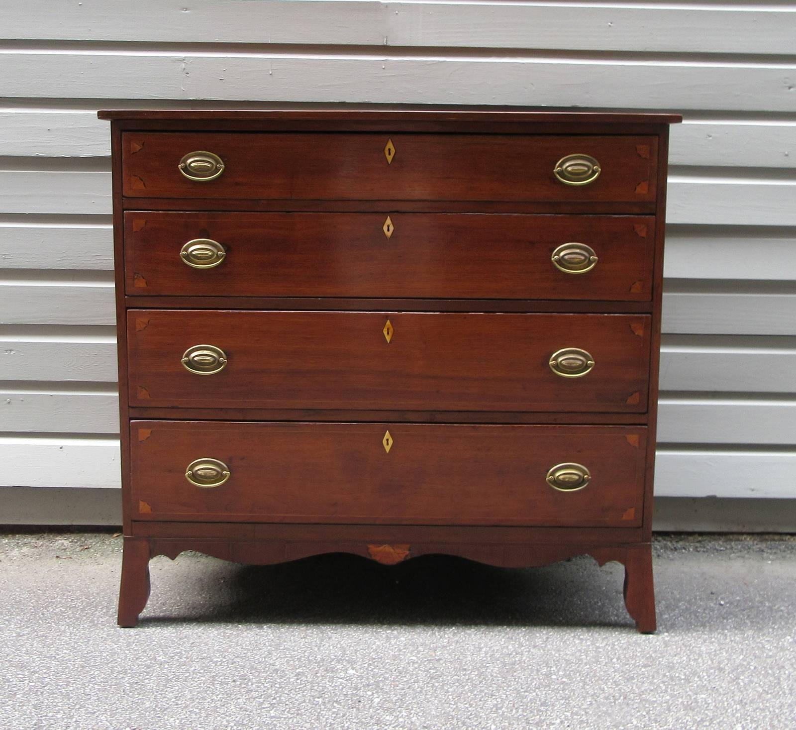 An early 19th century Virginia Federal walnut chest of drawers, circa 1800, with four drawers, compass and fan motif inlay and original brasses. The secondary wood is yellow pine.