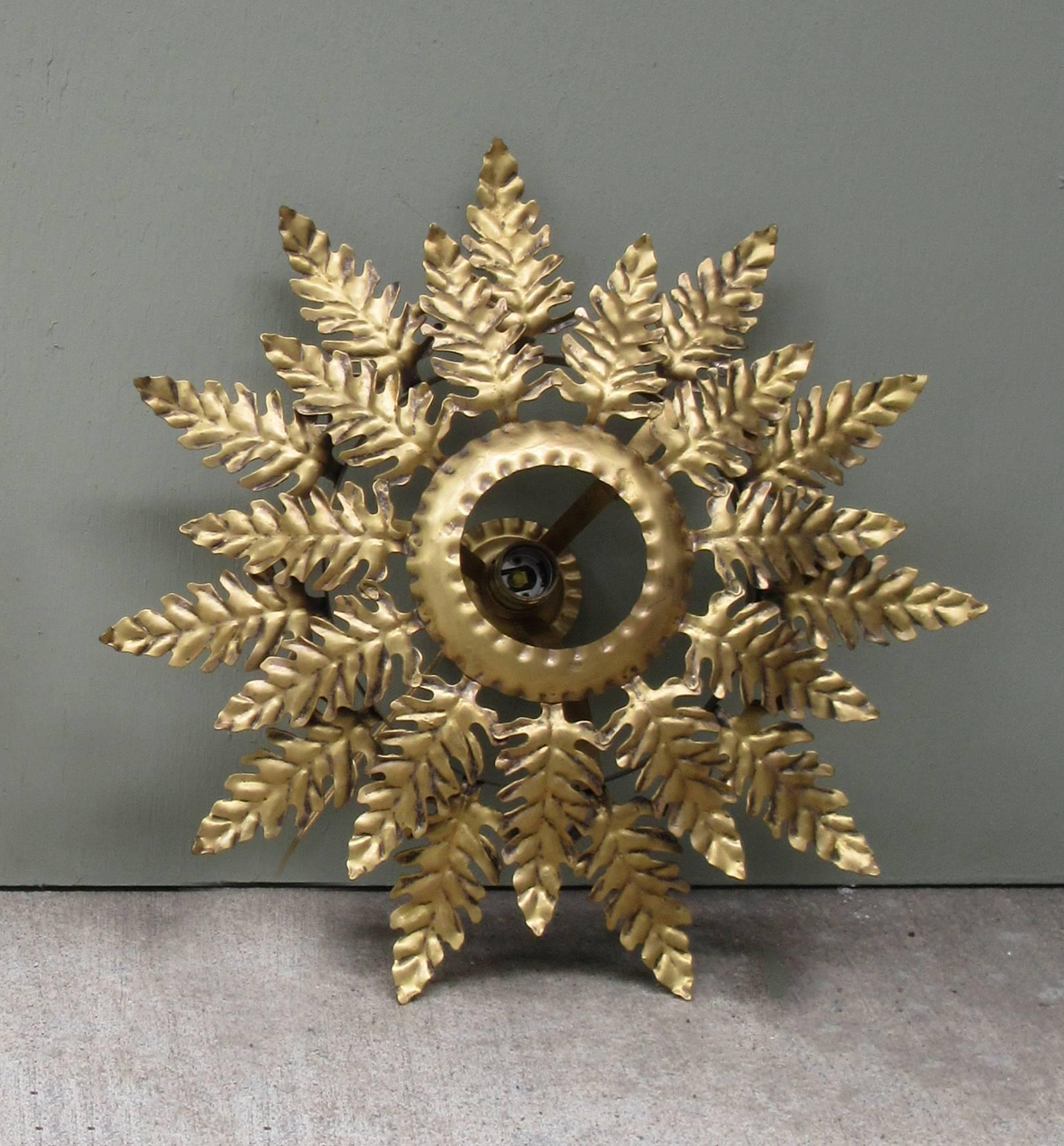 A 20th century Spanish Barcelona gilt tole flush mount light fixture, circa 1930, featuring palm fronds arranged in a starburst pattern. The fixture has been rewired and has a new porcelain socket.