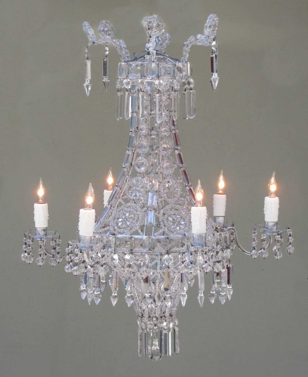 An early 20th century Italian neoclassical crystal and tole chandelier, circa 1900, featuring a basket shaped body woven with high-grade crystal beading and prisms, six candle arms with beaded bobeche and three tiers of large pendant drops. The