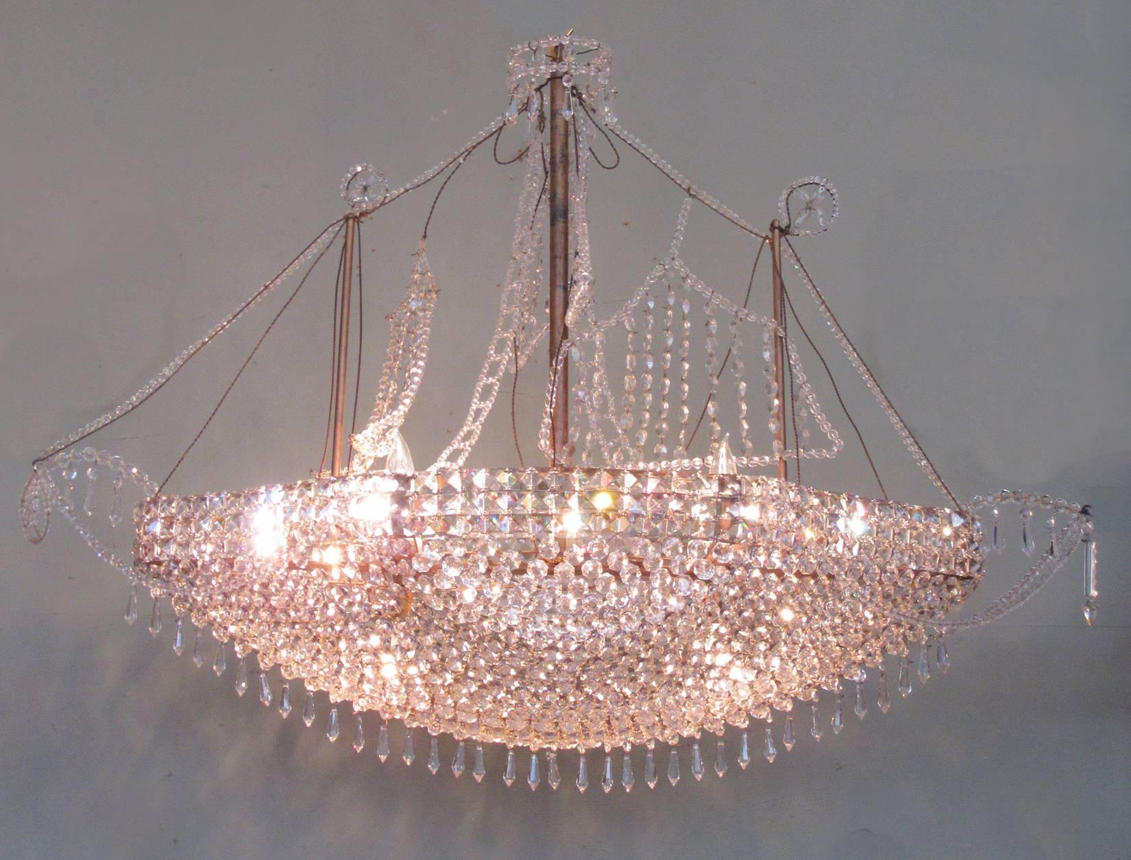 This chandelier was made in the mid-20th century, circa 1960. This chandelier is made of French crystal and features several different sizes of crystal beads formed into the shape of a chinoiserie ship. It is truly magnificent in person! The fixture